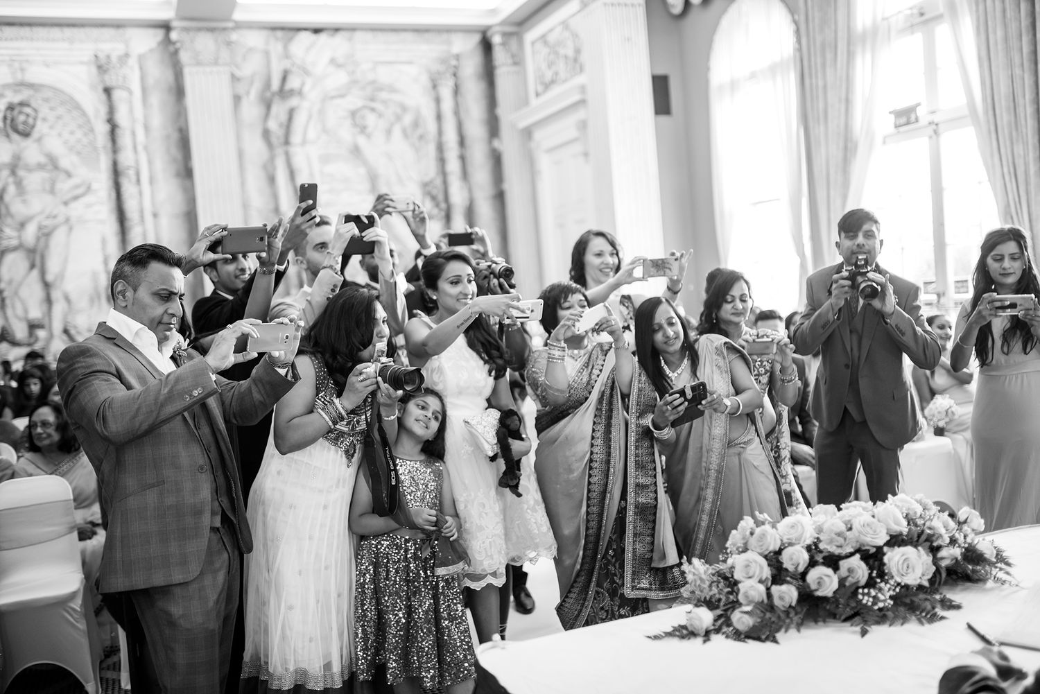 Elegant wedding venue interior with ornate moldings and gathered guests.