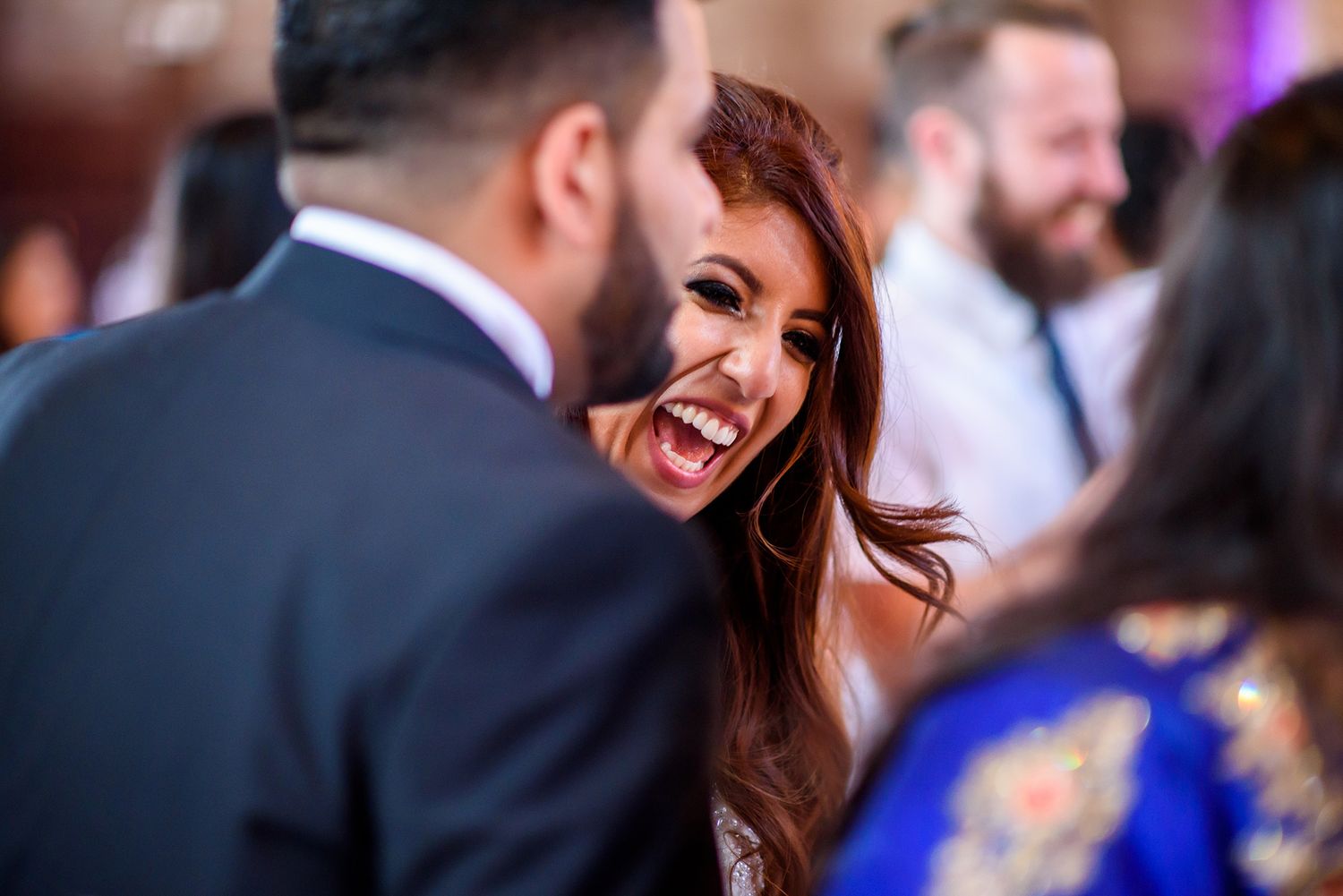 Guests share joyful moments during an elegant indoor reception celebration.
