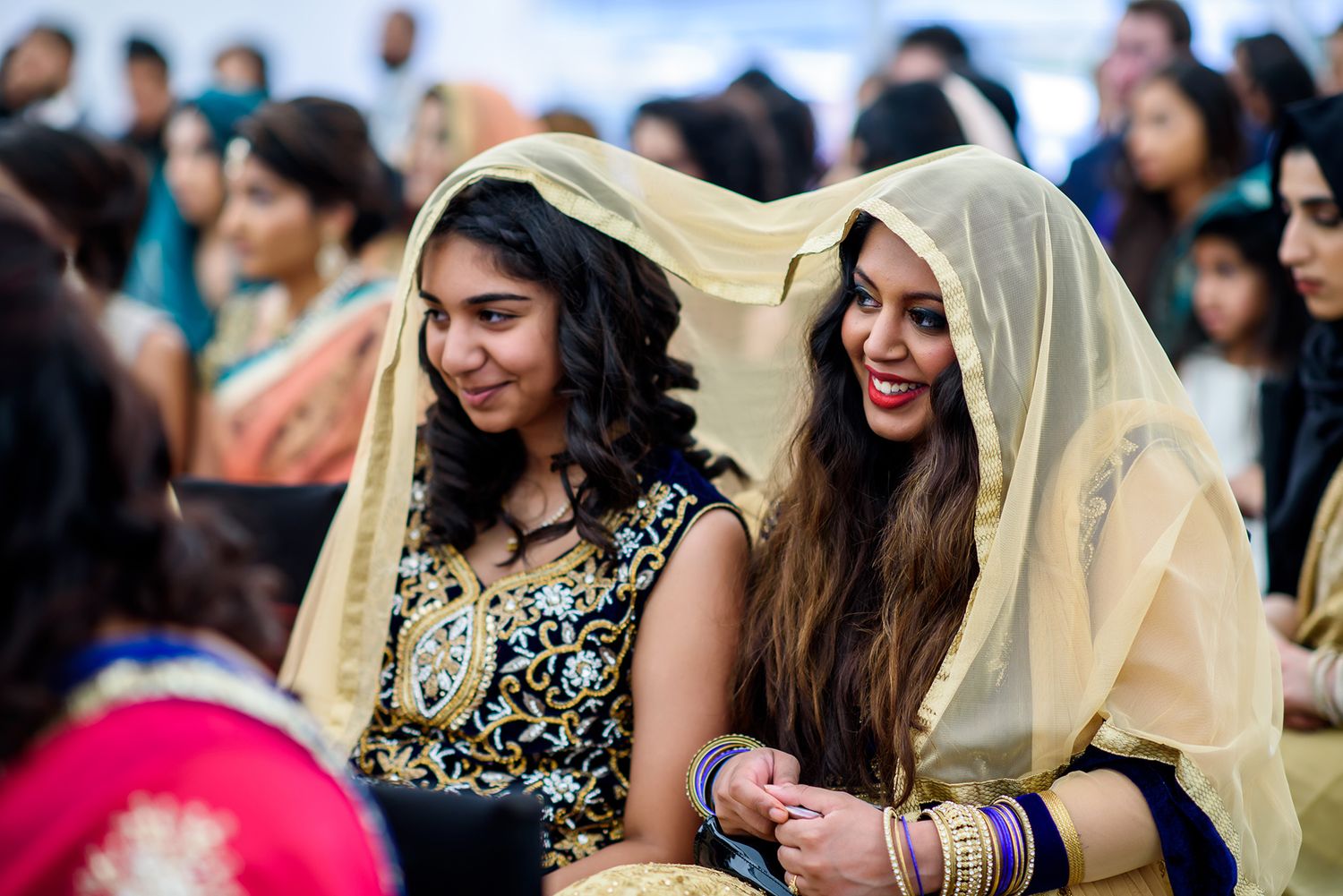 Guests in colorful traditional attire enjoying themselves at a festive celebration.