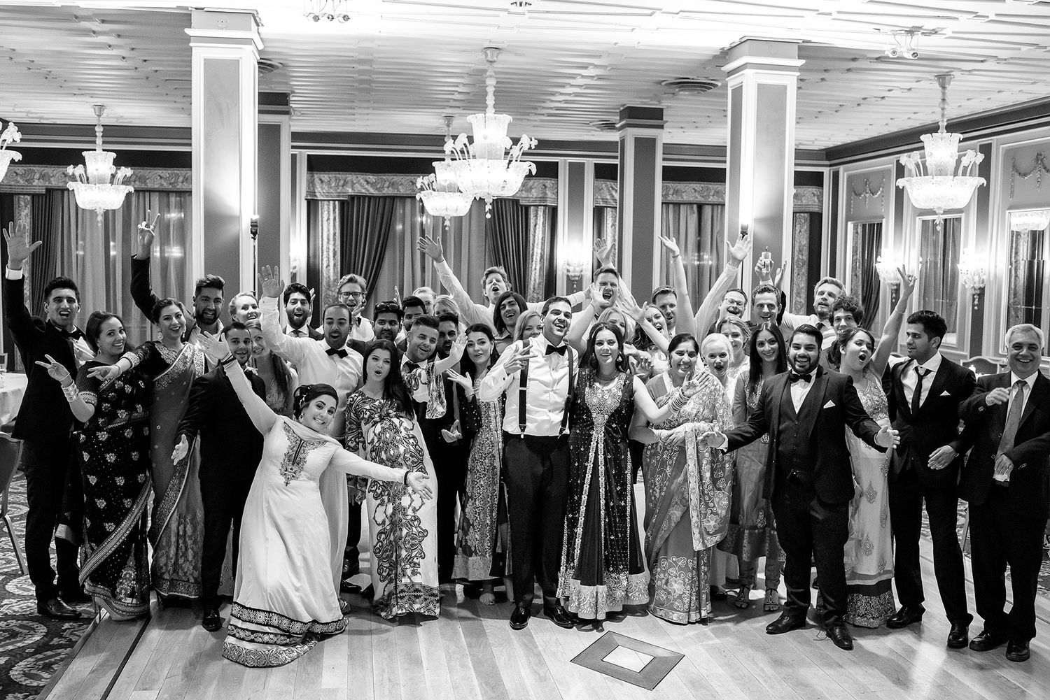 Large group gathered in an elegant venue hall for a formal event.