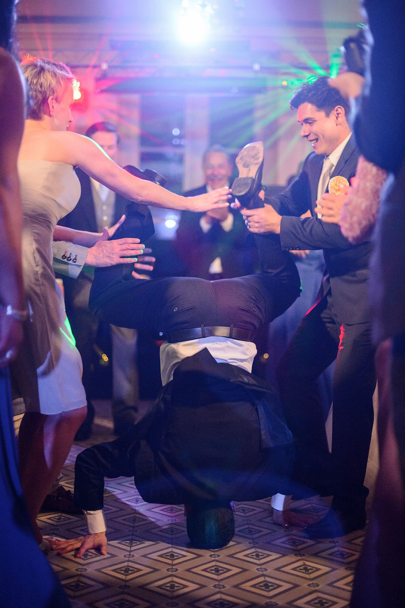Wedding reception dance floor with guests dancing under dramatic blue and purple lighting.