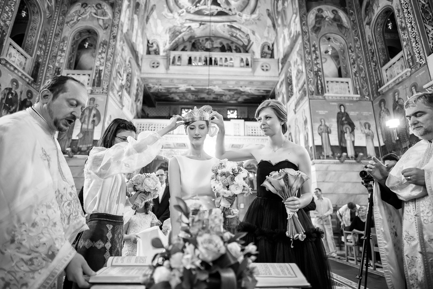 Orthodox church wedding ceremony with ornate gold decorations and religious iconography.