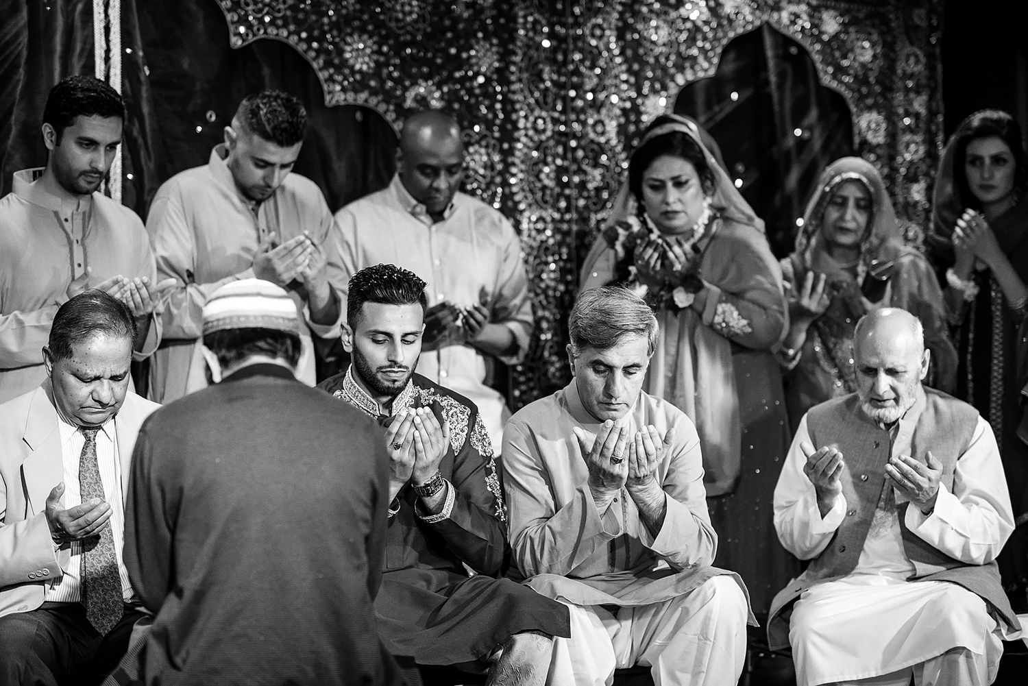 Group of wedding guests enjoying an outdoor celebration with festive lighting.