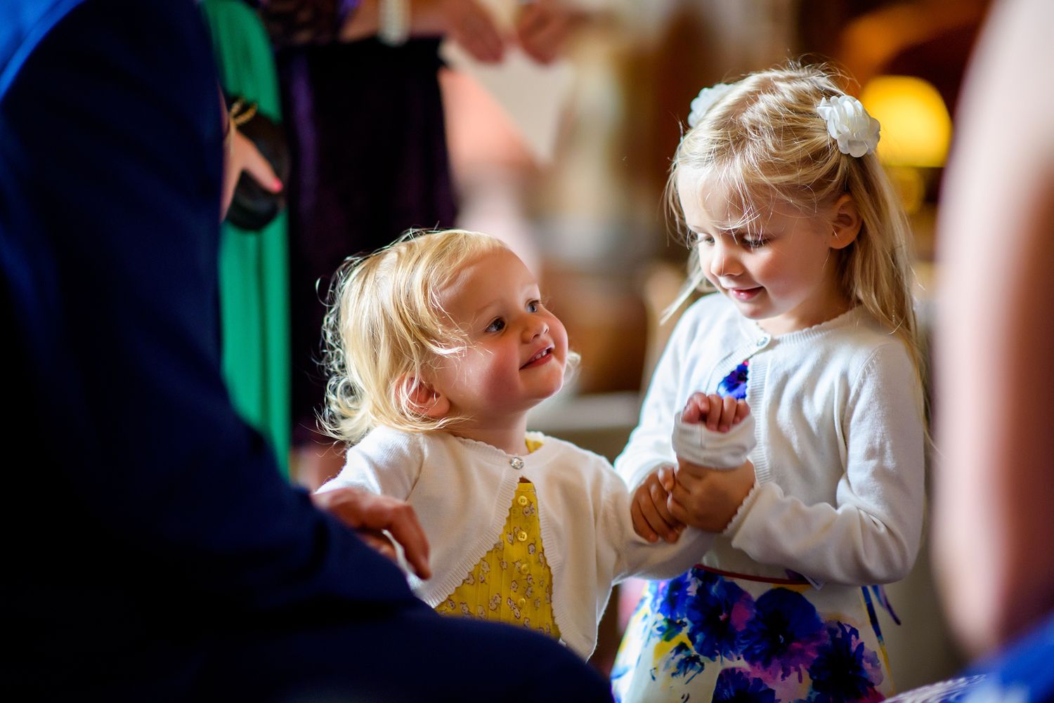 Children playing and laughing together at indoor wedding reception.