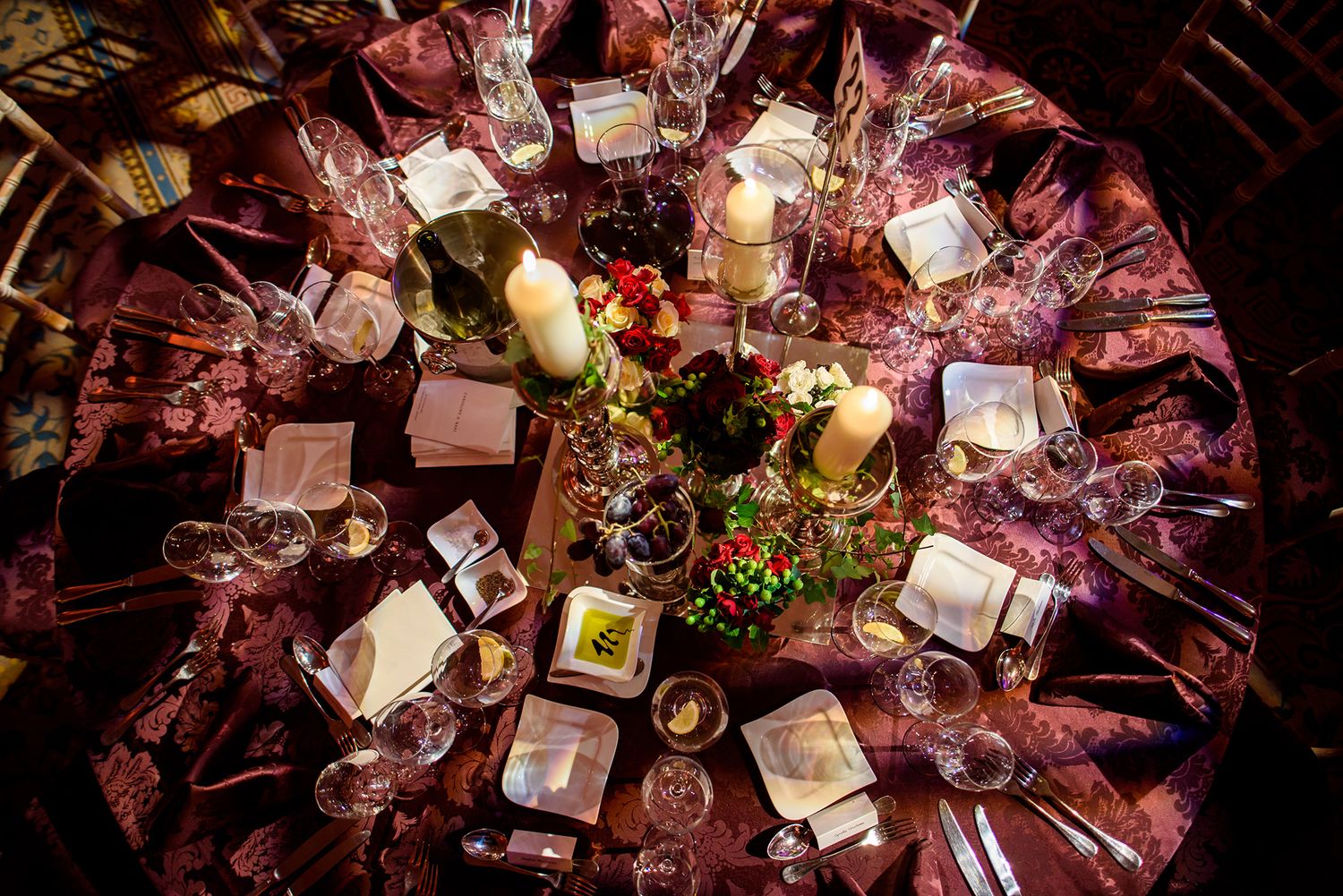 Overhead view of elegant table settings with wine glasses and place cards at a formal event.