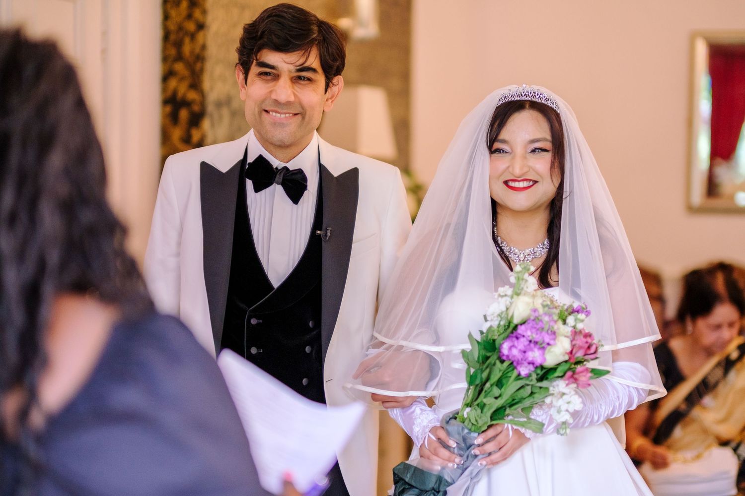 A traditional indoor wedding ceremony with elegant decor and guests gathered to celebrate the occasion.