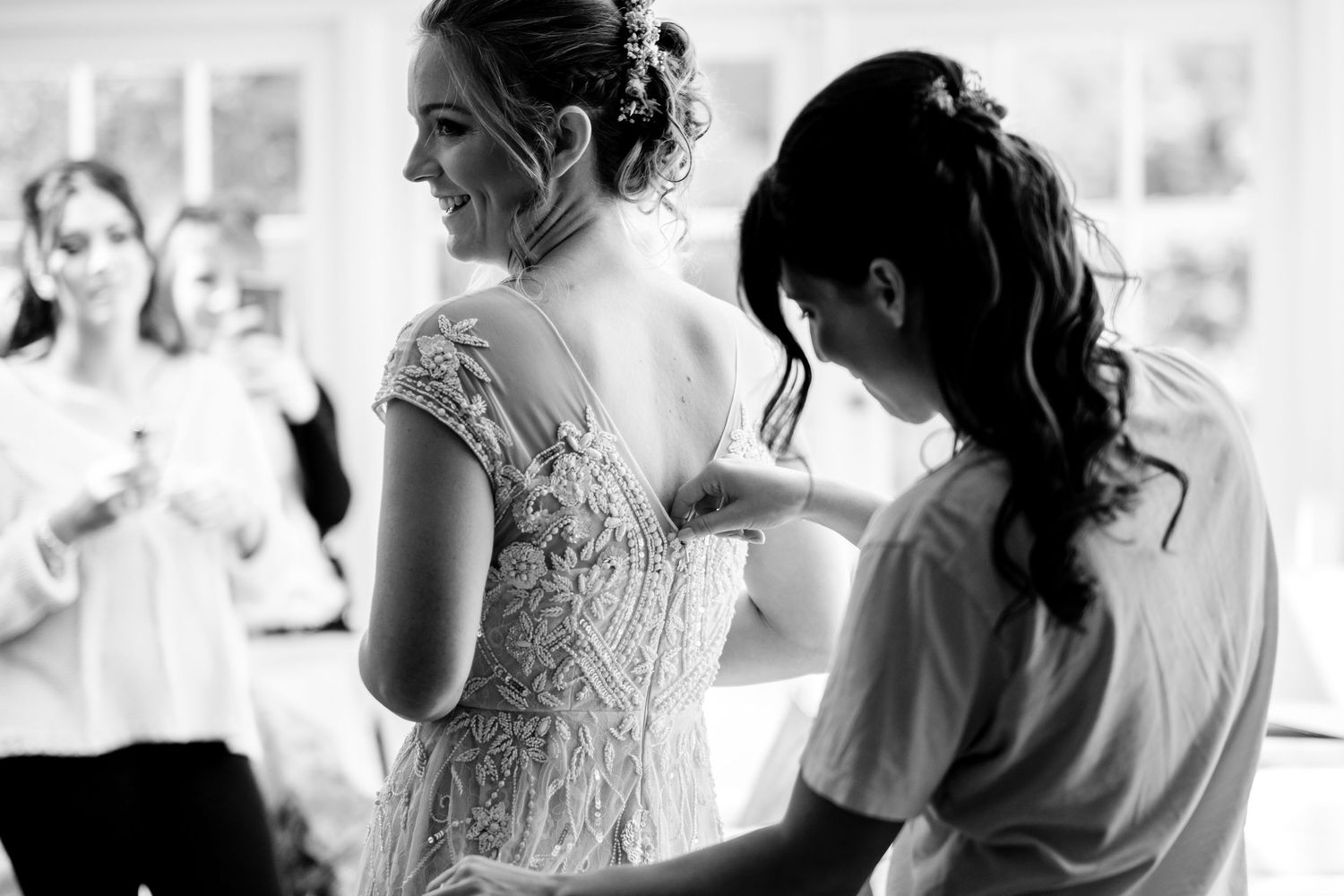 Black and white photo of a wedding preparation scene with elegant lace details.