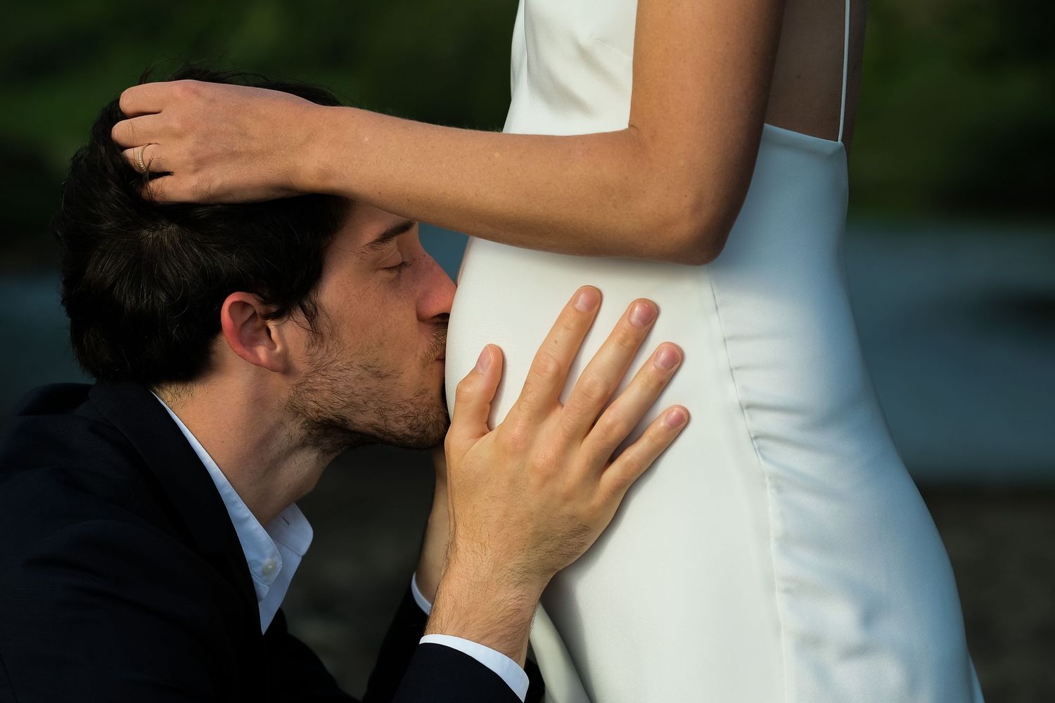 Close-up detail of couple embracing during intimate wedding moment outdoors.