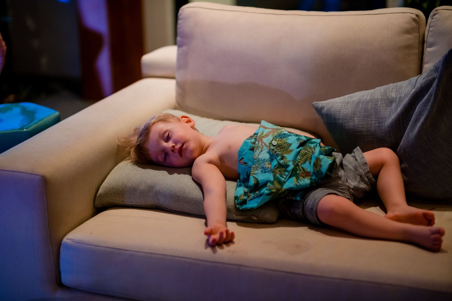 A person sleeping peacefully on a couch in a casual home setting.