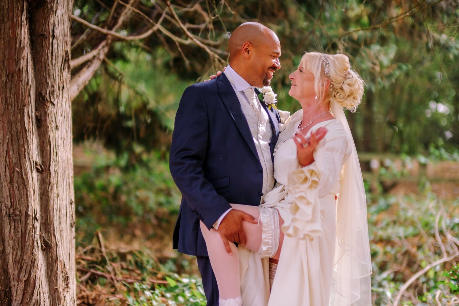 A couple shares romantic moments in a forest setting during their wedding photo session.