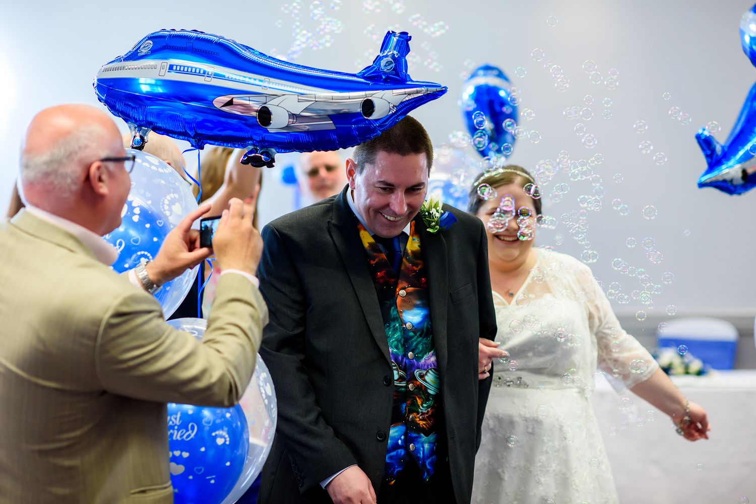 Wedding guests blowing blue bubbles during a joyful celebration.