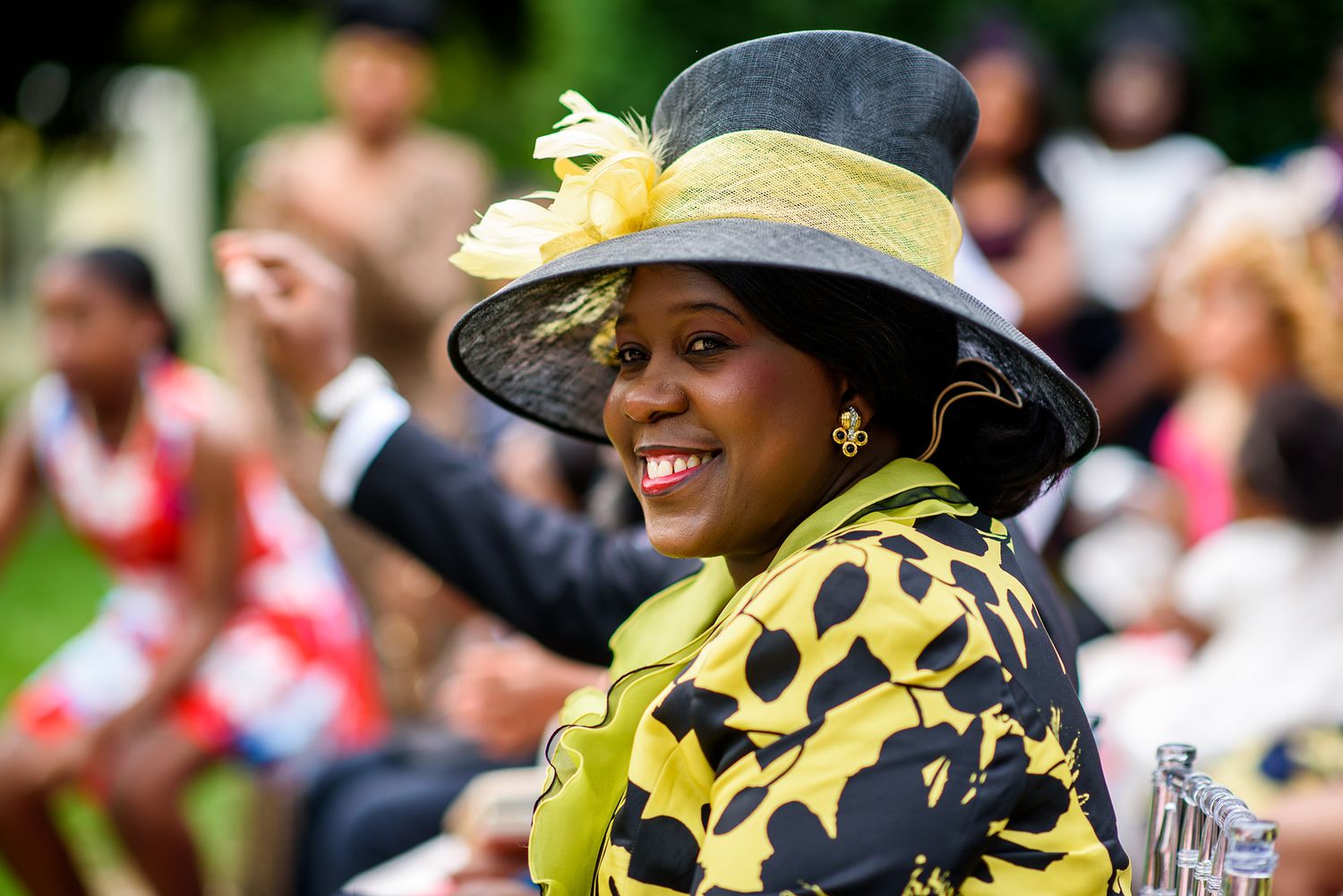 Guests in decorative yellow and black hats enjoying an outdoor celebration.