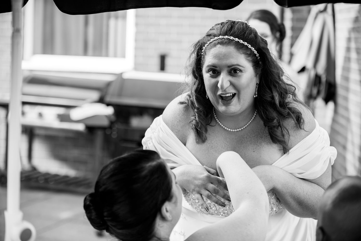 Bridesmaids helping with final wedding preparations in a bright indoor setting.