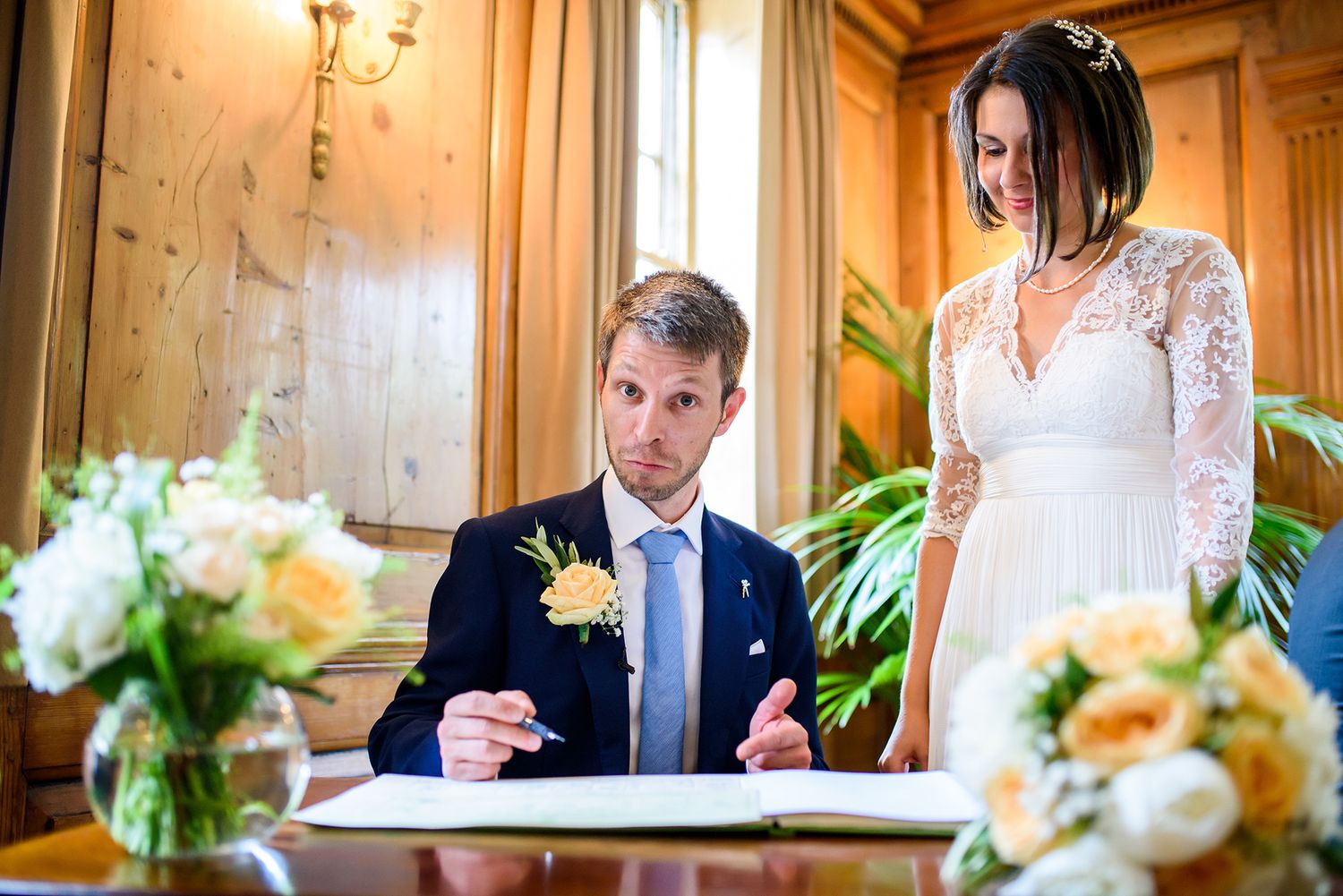 Elegant wood-paneled reception venue with floral centerpieces and warm lighting.