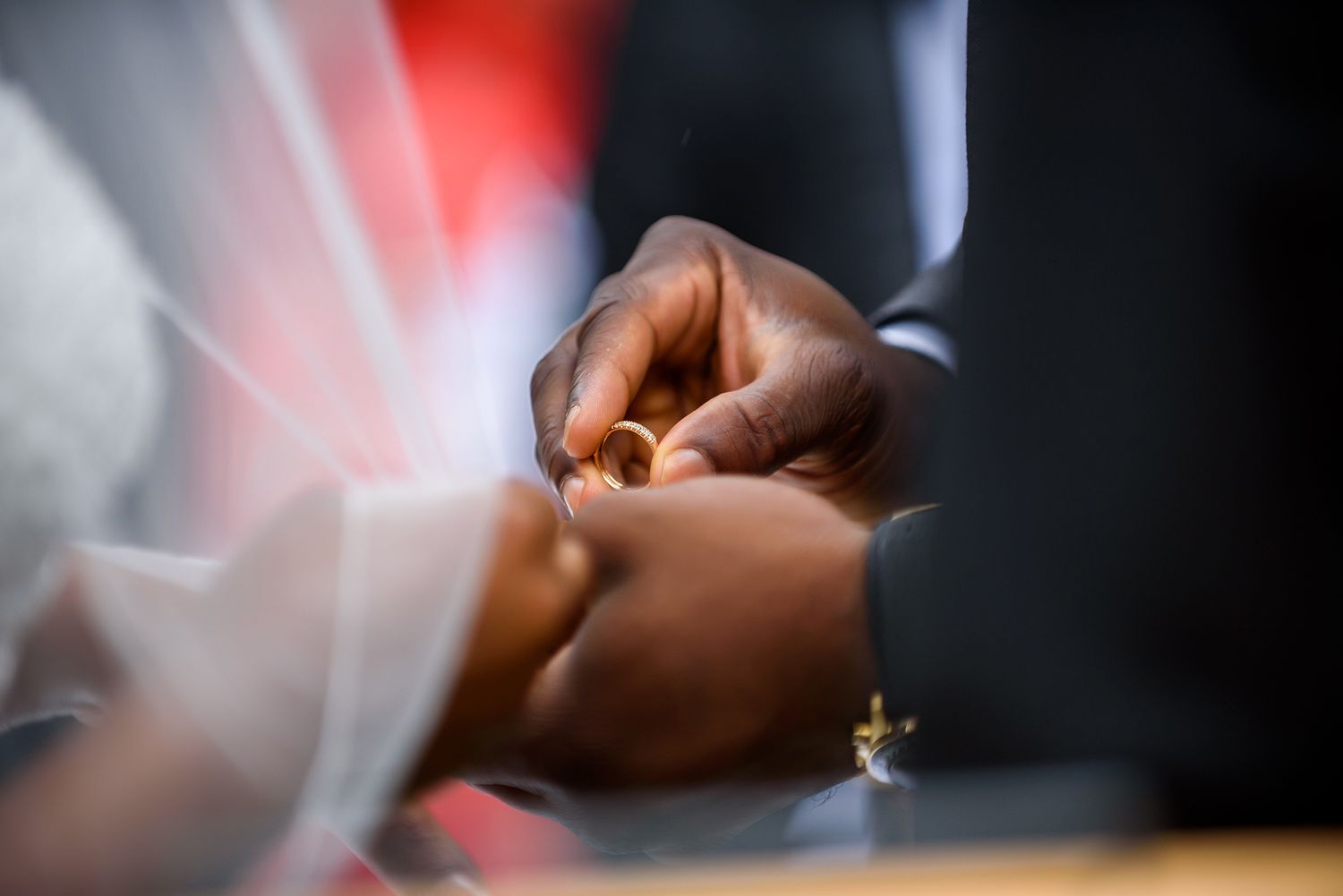 Close-up detail shot of hands during wedding ceremony veil adjustments.