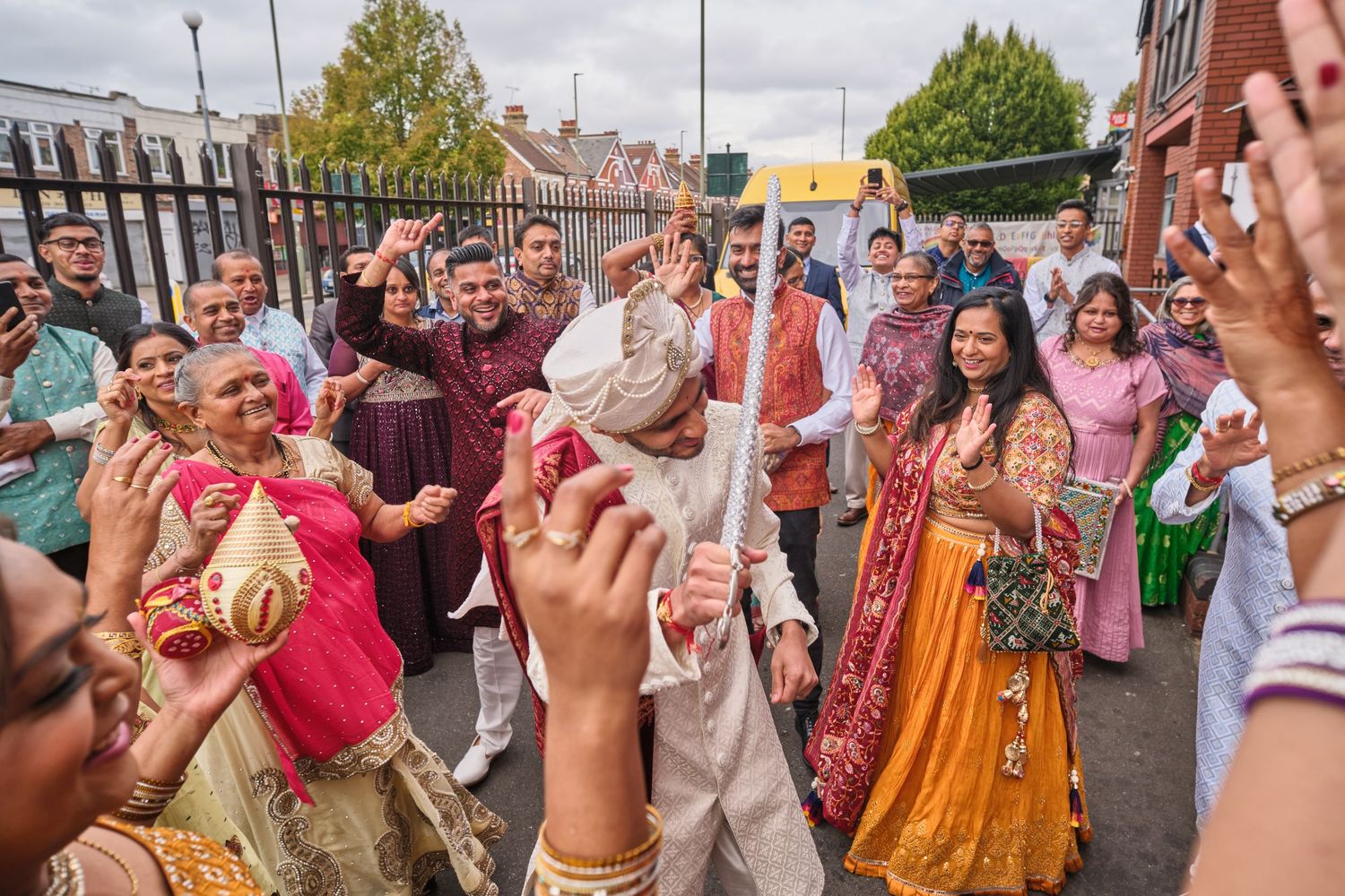 Large group celebrating outdoors with traditional Indian attire and festivities.