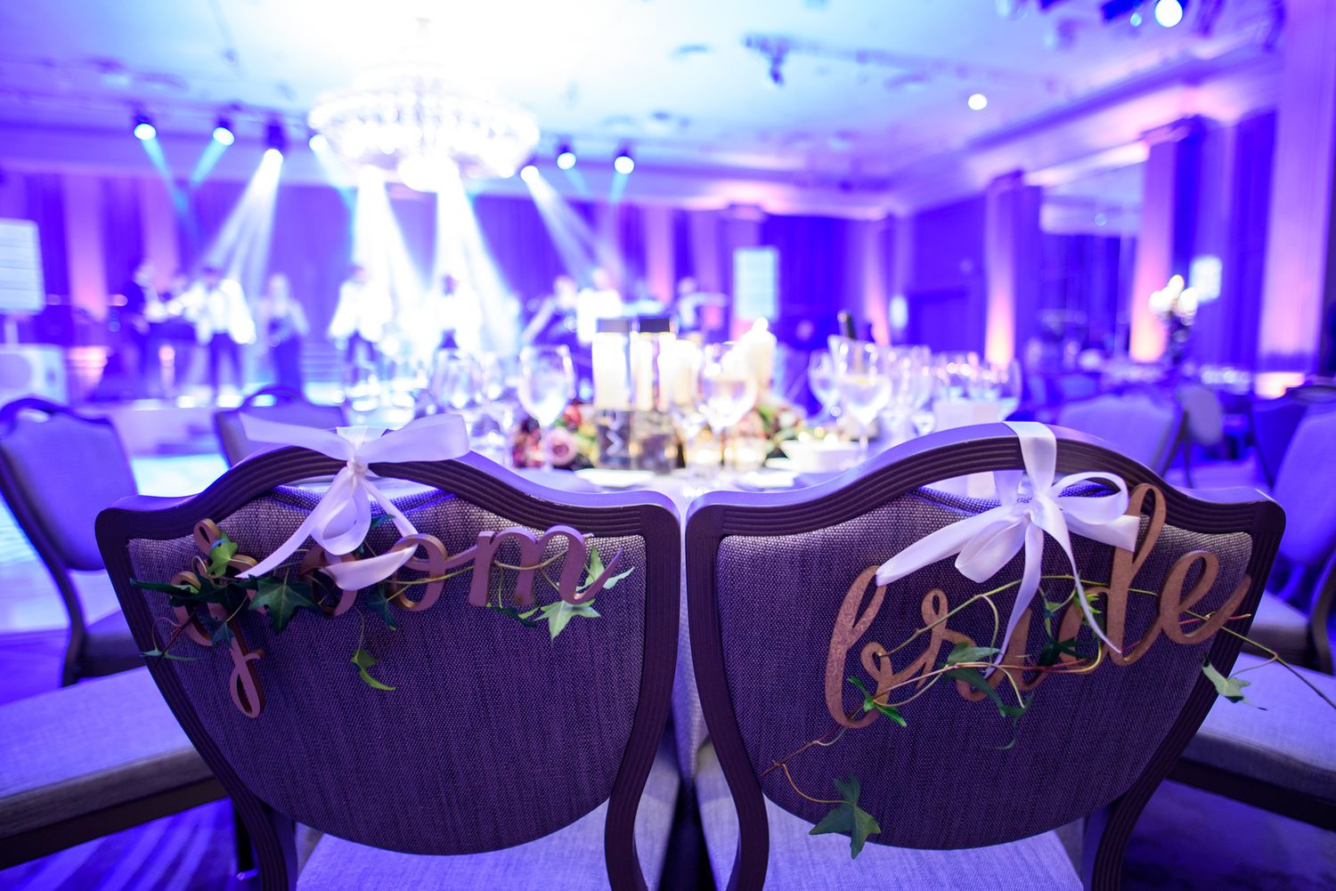 Luxurious banquet hall with dramatic blue lighting and ornate upholstered chairs.