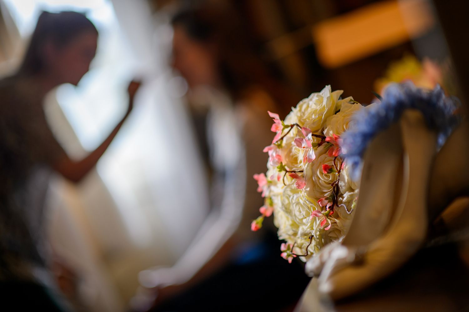 Close-up of delicate pink and white floral wedding decorations on reception tables.