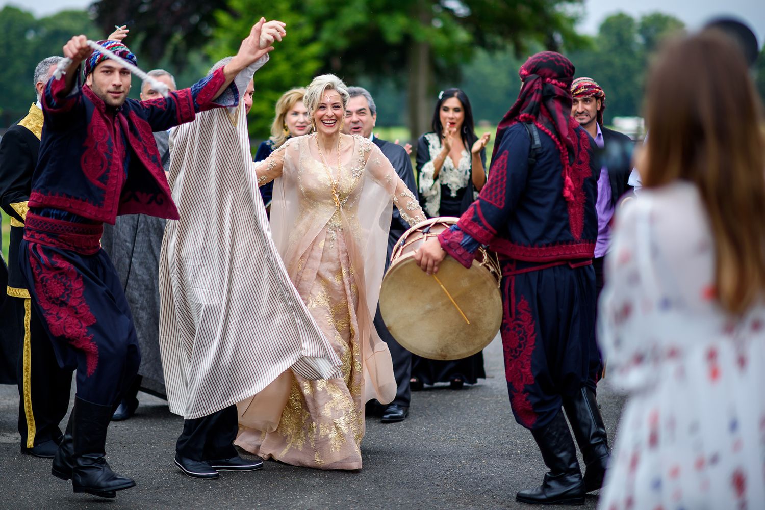 Wedding party members walking outdoors in formal attire.
