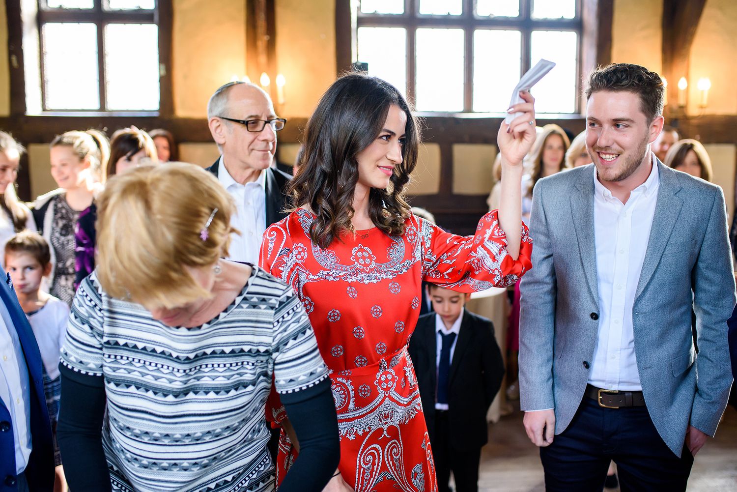 Wedding guests celebrating and socializing in a traditional timber-framed reception hall.