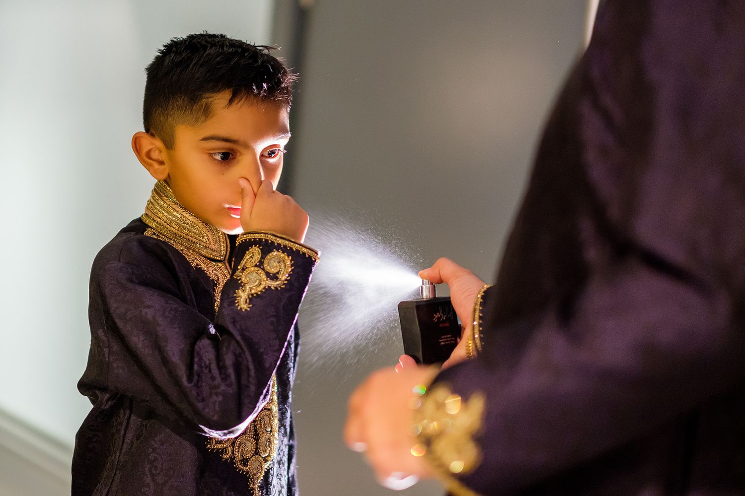 Young guest in formal attire at an indoor celebration.