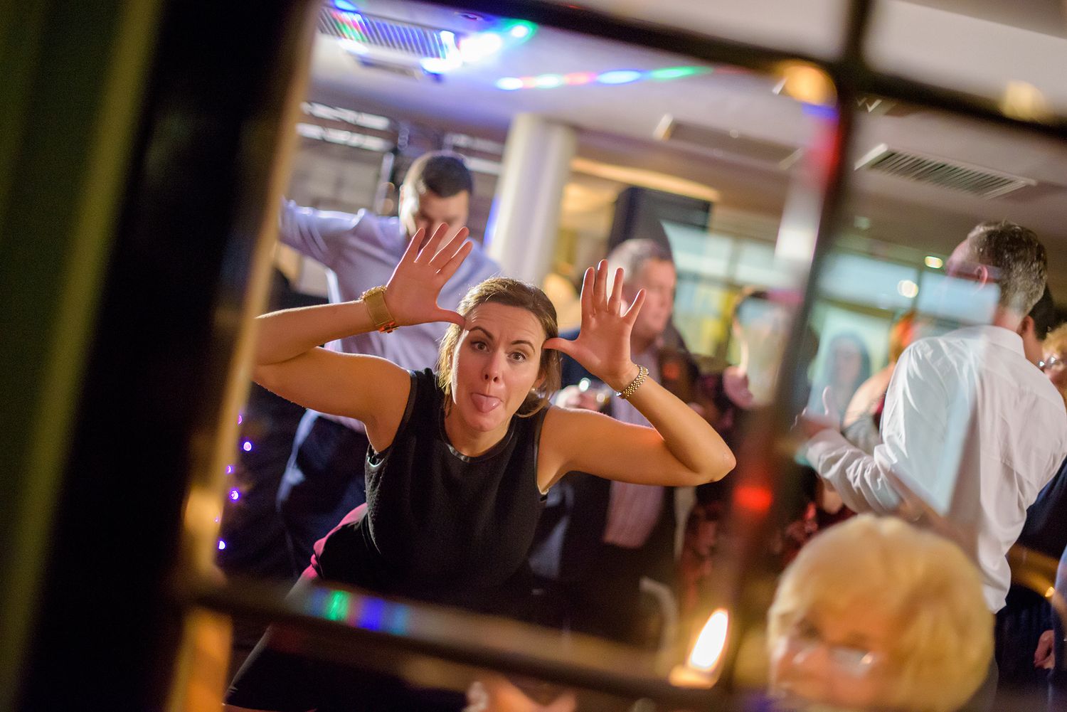 Energetic dance floor moments captured at a wedding reception with dramatic lighting effects.
