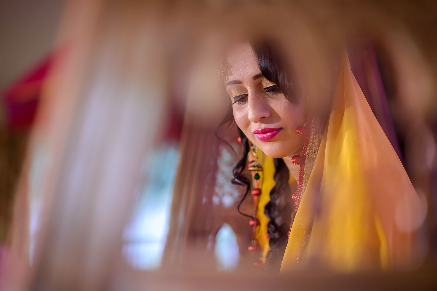 Close-up wedding photography showing intricate bridal jewelry and makeup details in warm tones.