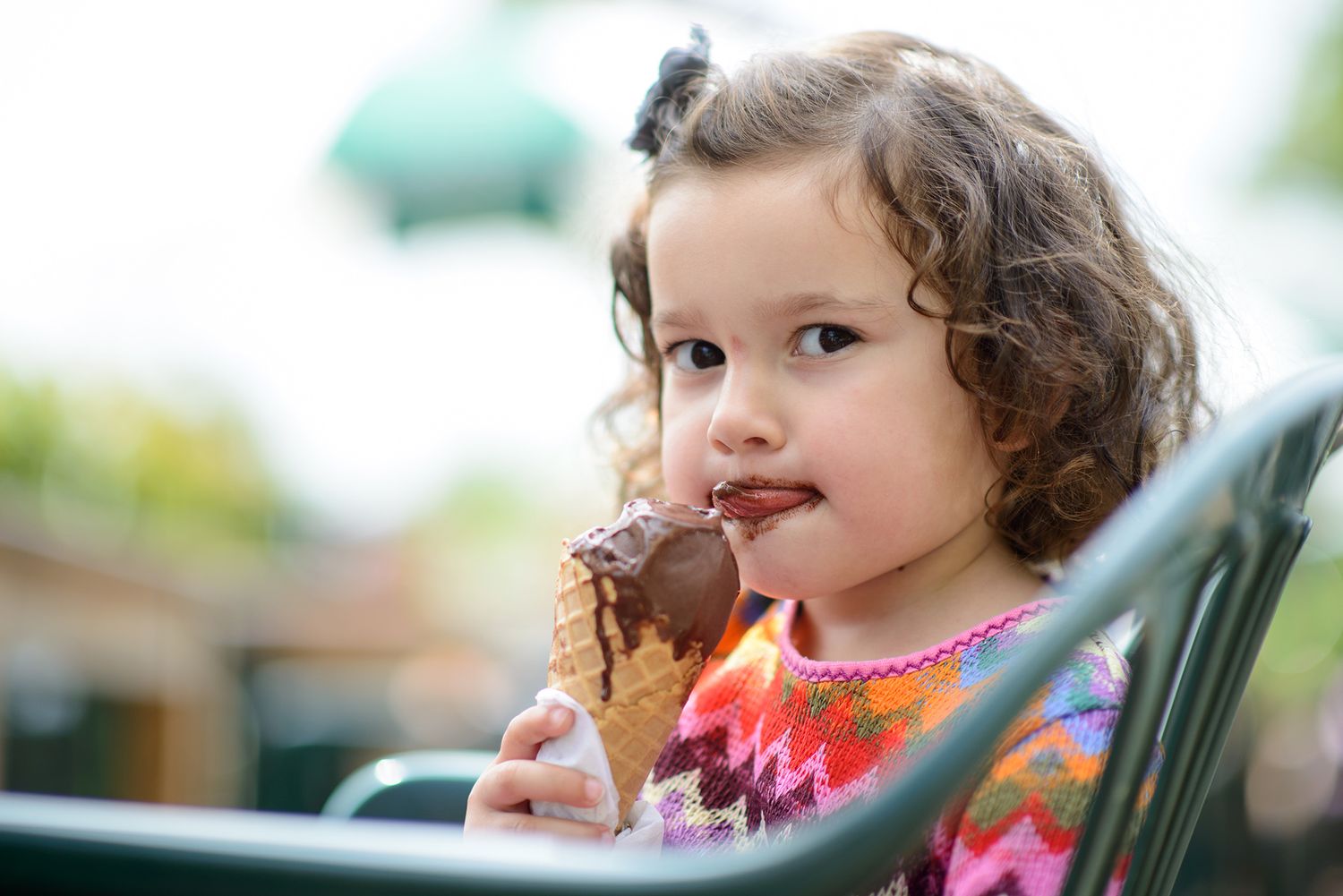 Child enjoying an ice cream cone outdoors on a summer day.