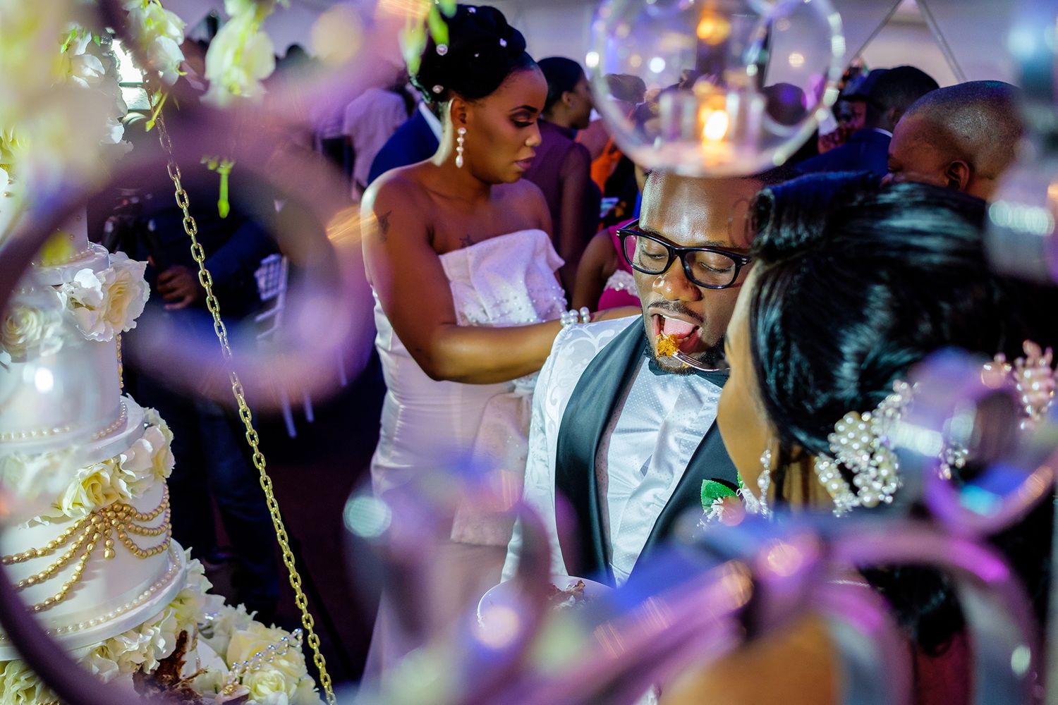 Wedding reception with colorful bokeh lighting effects and dancing guests.