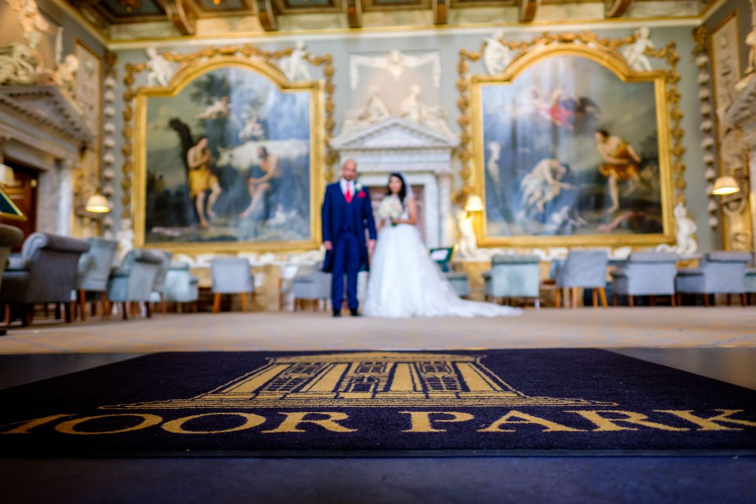 A grand wedding scene in an ornate hall with classical paintings and gilded frames.