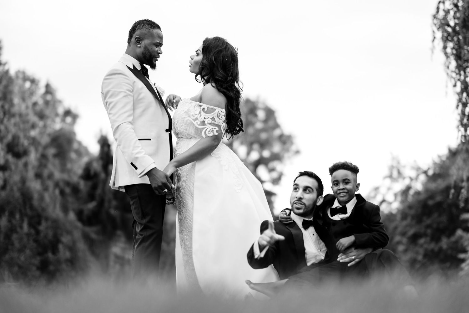 Wedding couple and wedding party sharing candid moments outdoors.
