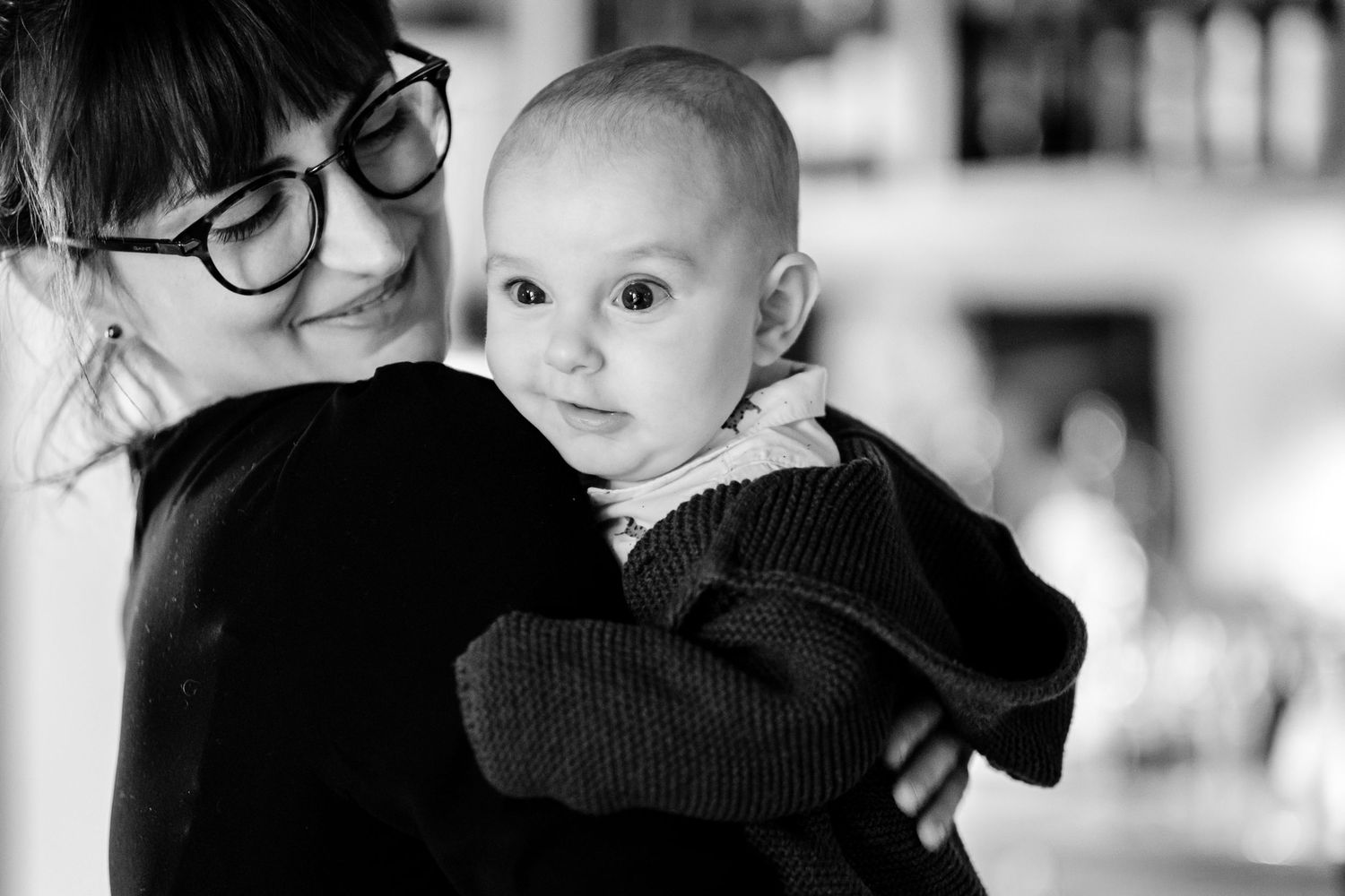 Black and white portraits showing tender moments between parent and child against a light background.