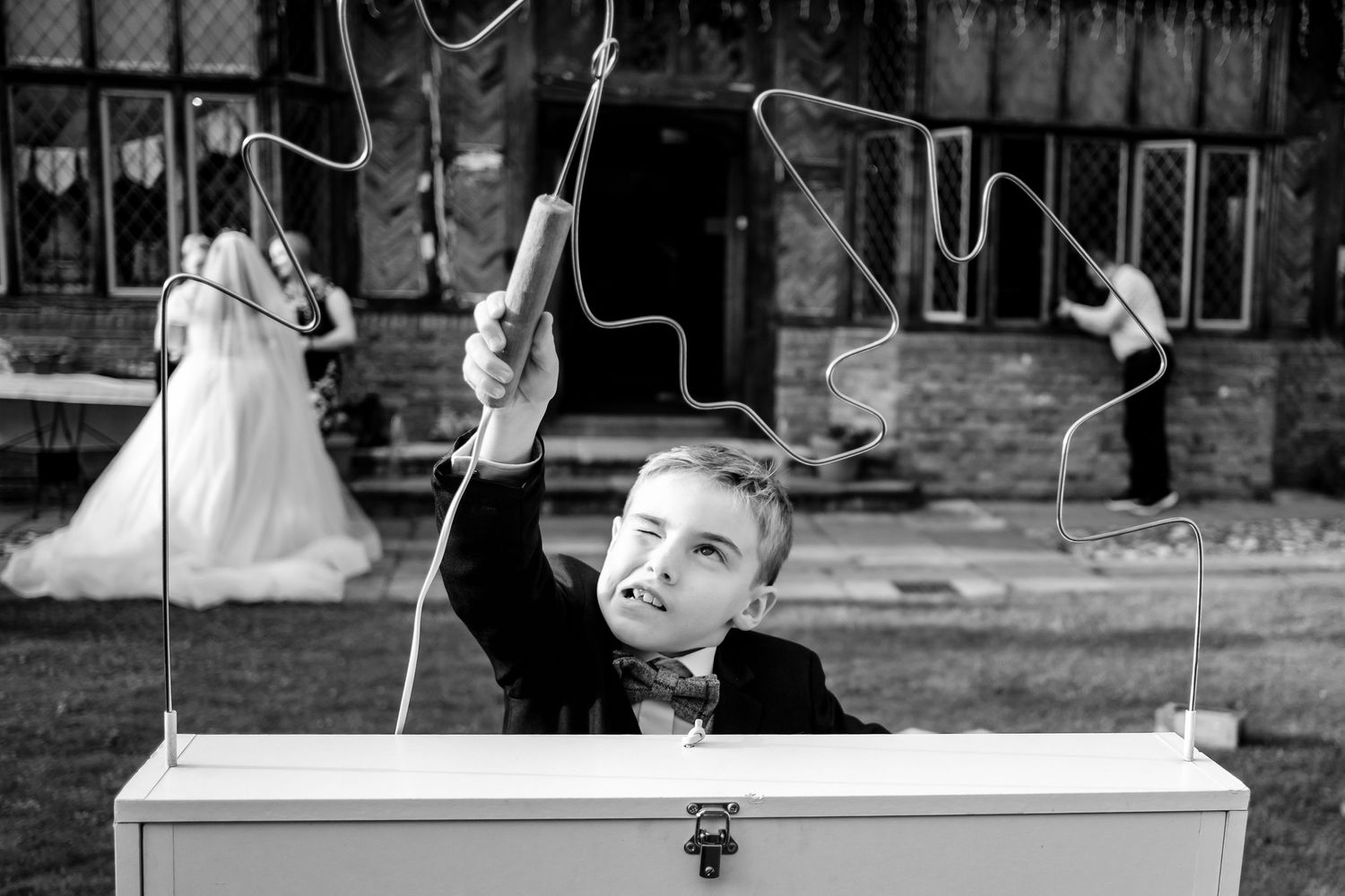 Black and white photograph shows wedding day couple silhouetted as they share their first dance on the dance floor.