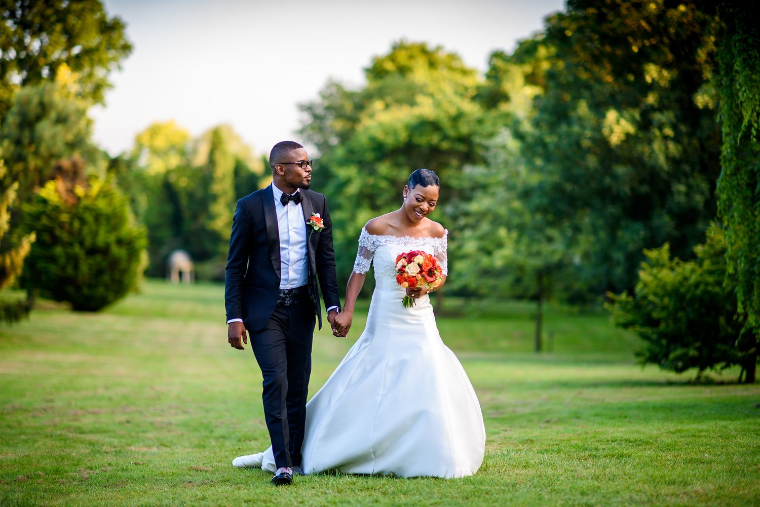 Outdoor wedding ceremony setup with elegant white decor and natural greenery backdrop.