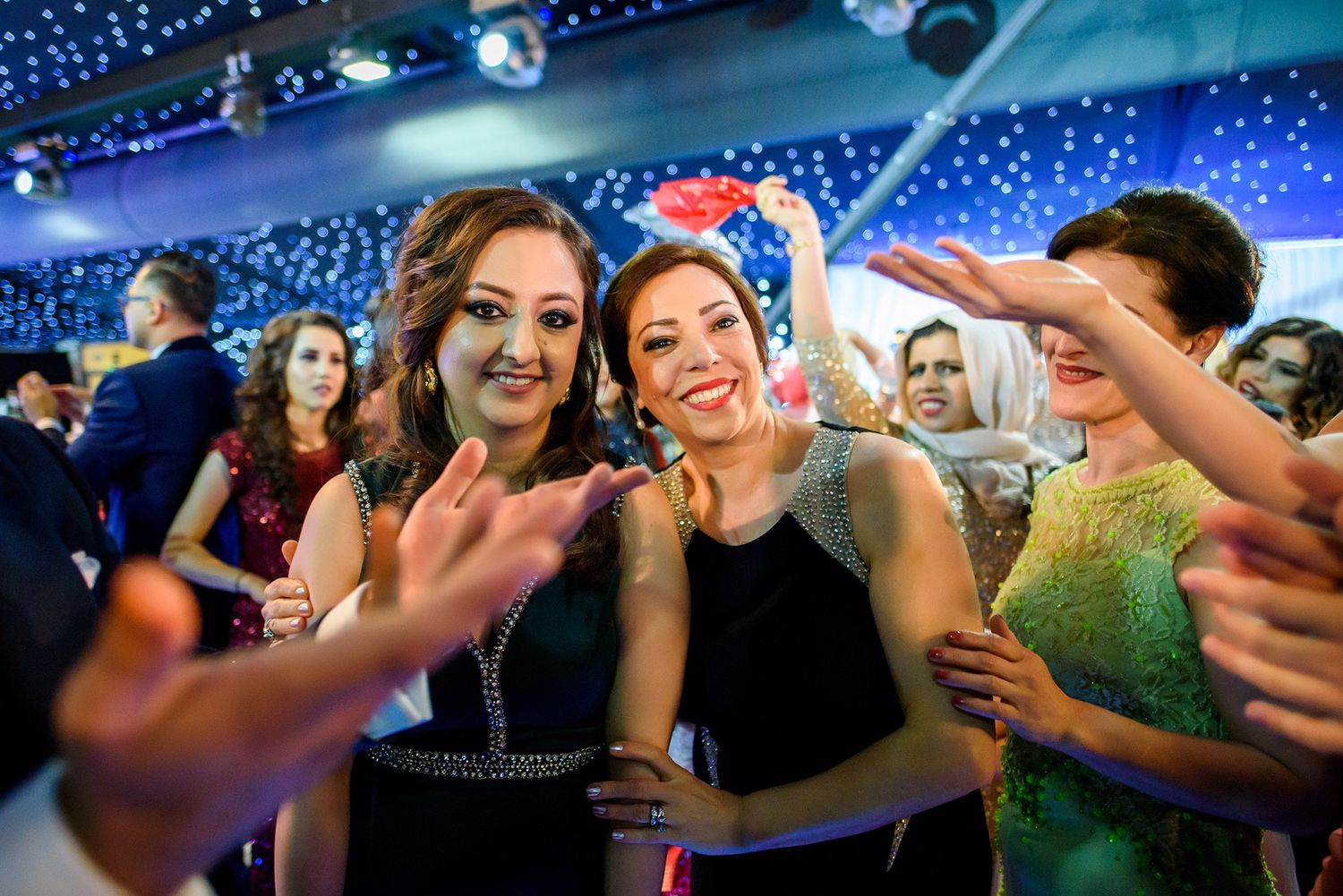 Celebration on dance floor with blue uplighting and twinkling star effects.