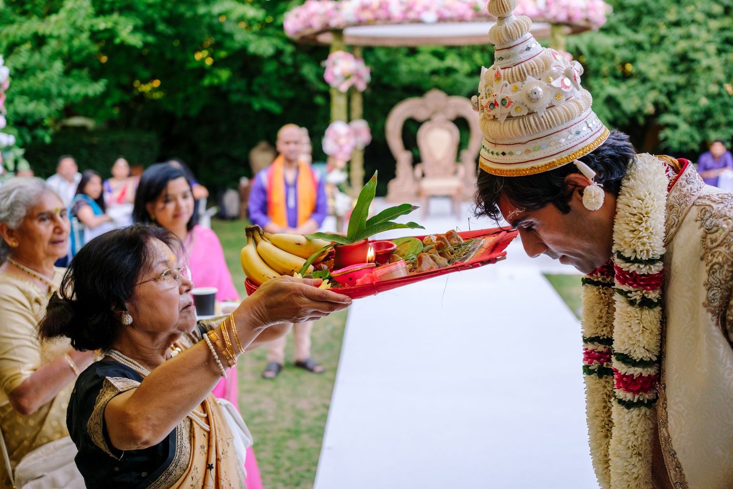 Wedding guests enjoy outdoor festivities with colorful decorations and drinks at a summer garden celebration.