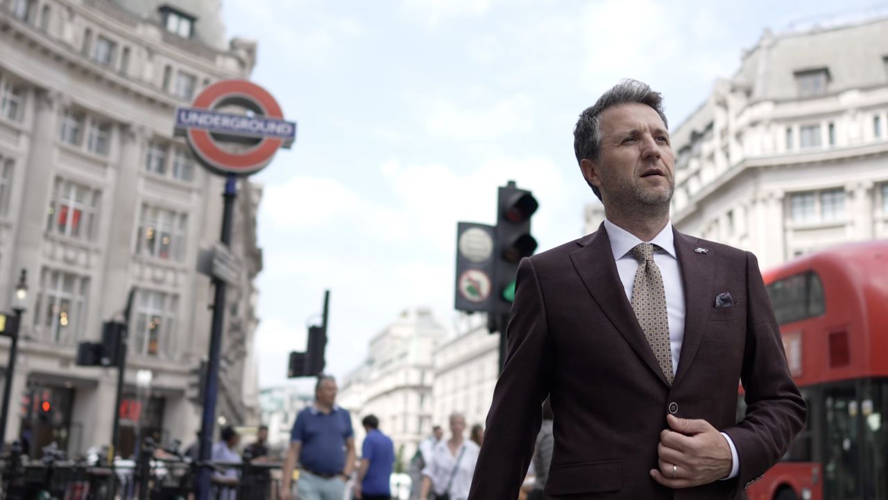 Urban London street scene with iconic Underground sign and red double-decker bus.