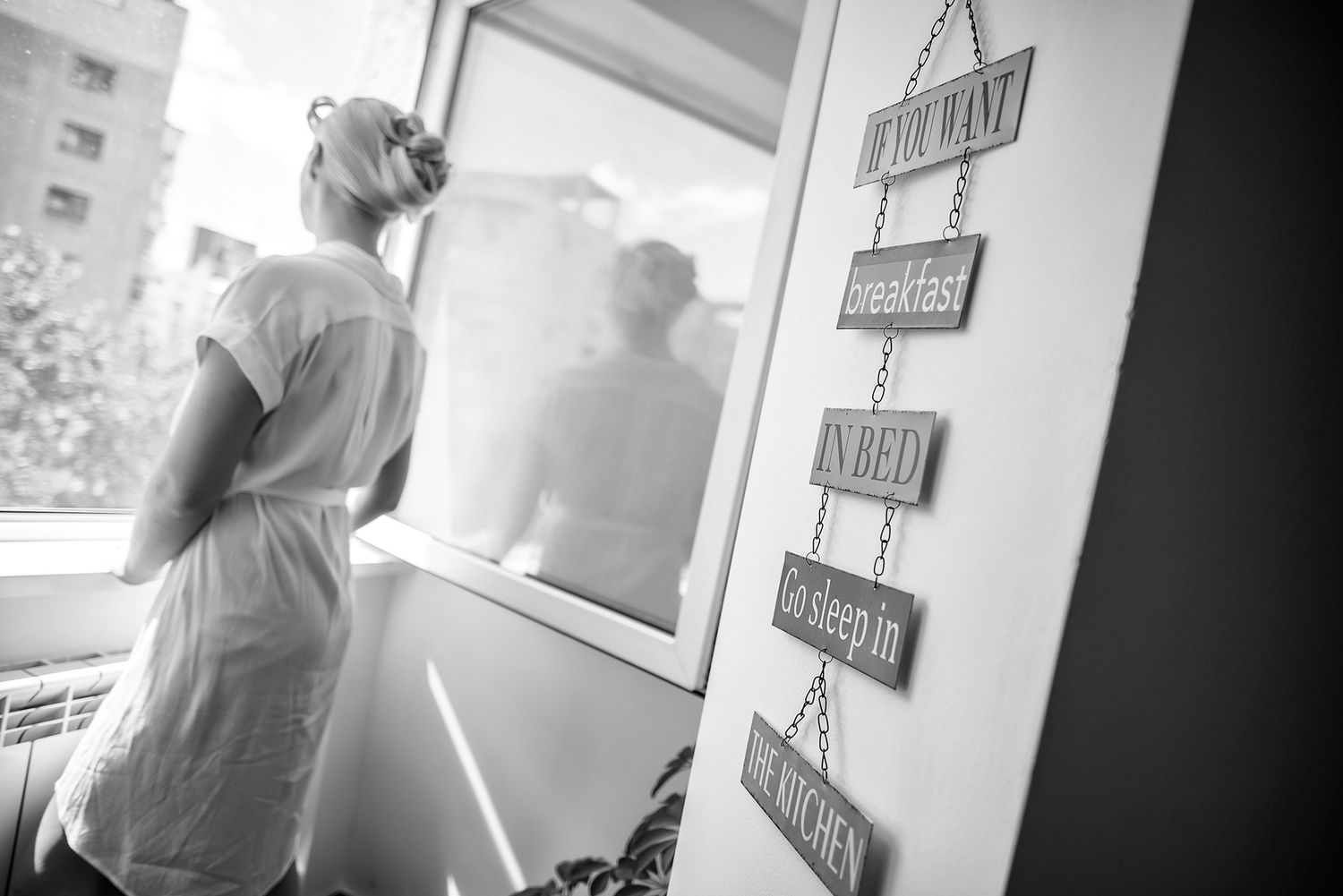 Black and white interior hallway shot with artistic lighting and wall decorations.