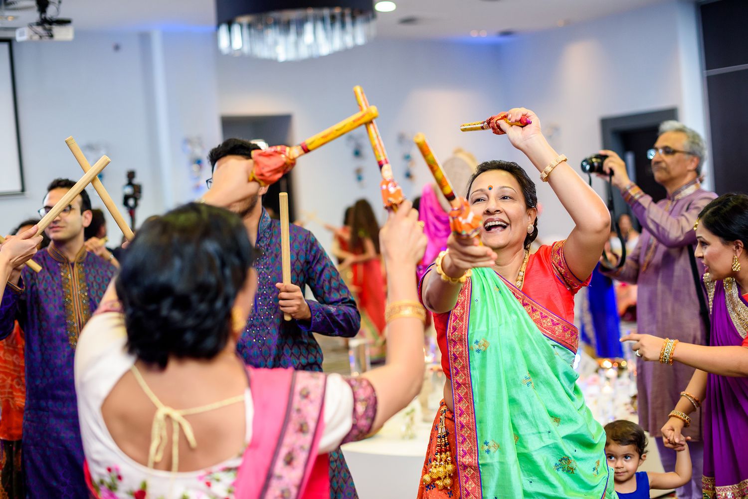 Spirited dancers in colorful lehengas and saris perform synchronized dance moves during a celebration.