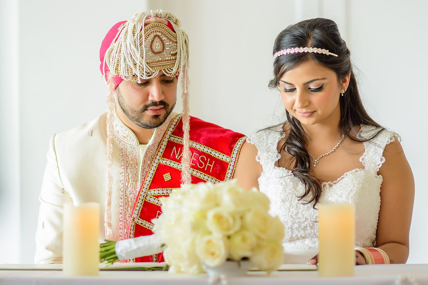 Traditional Indian wedding ceremony details with white floral arrangements and candles.