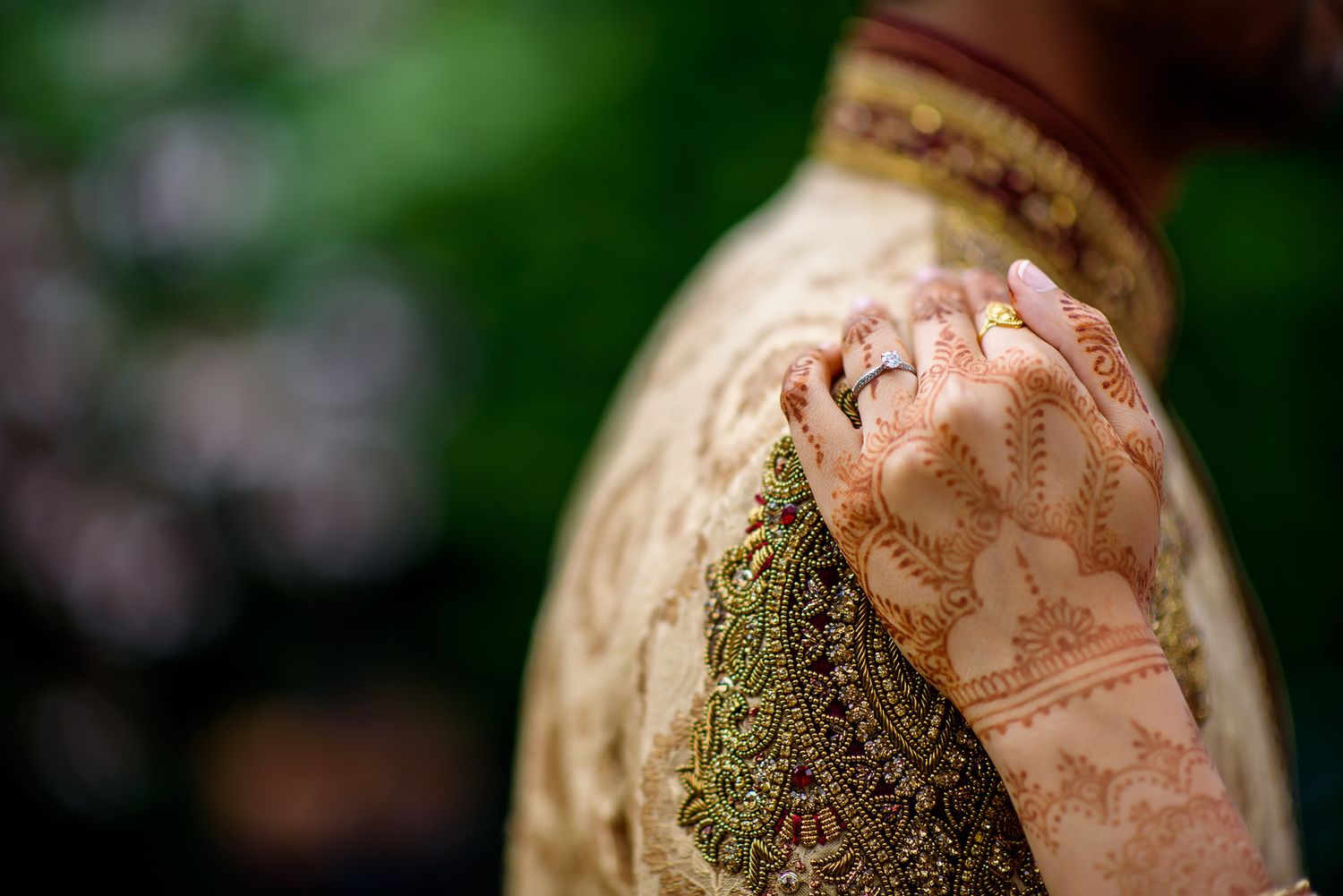 Intricate henna designs decorating hands with traditional jewelry accents.