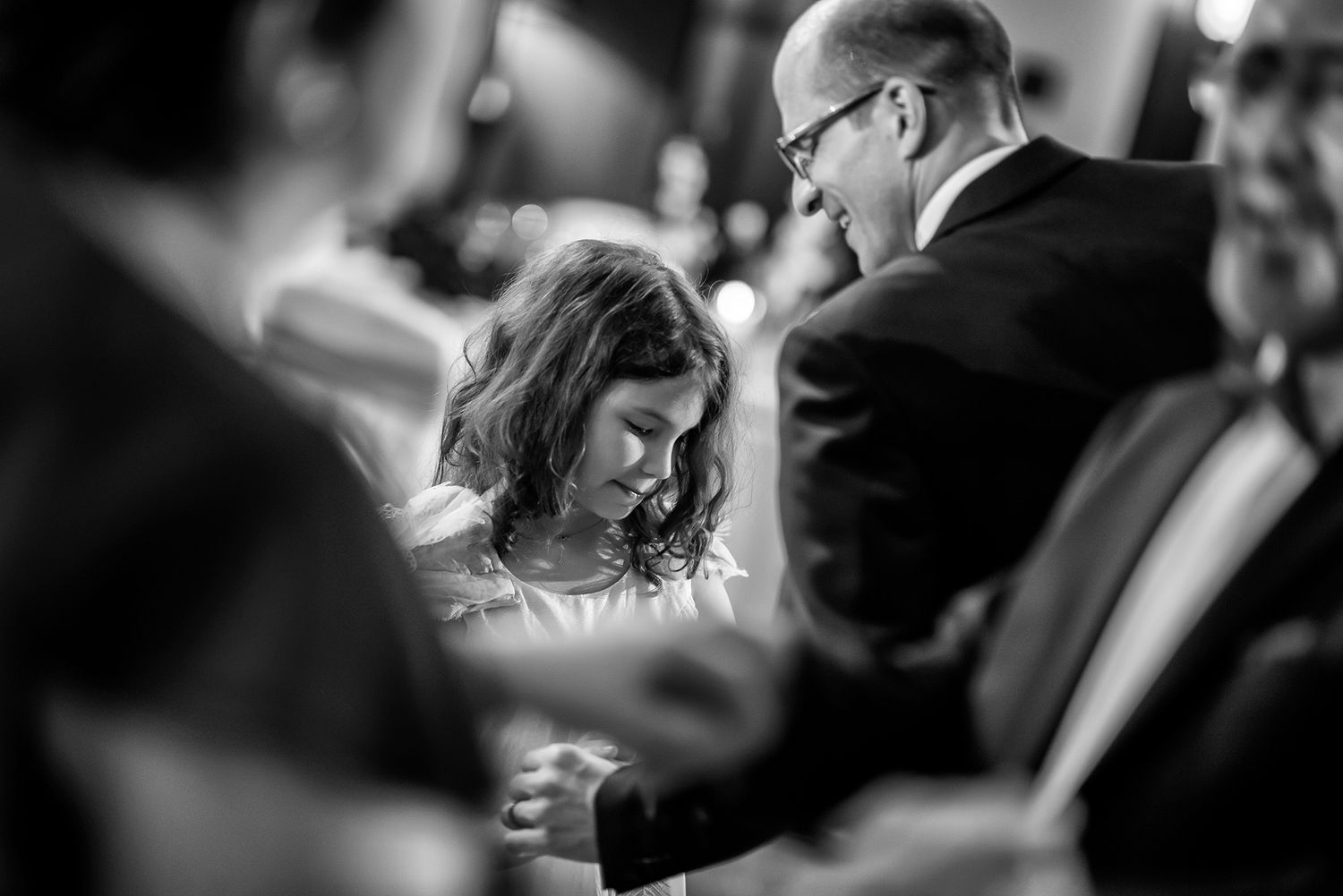 Wedding guests interact and share laughter during an evening reception celebration.