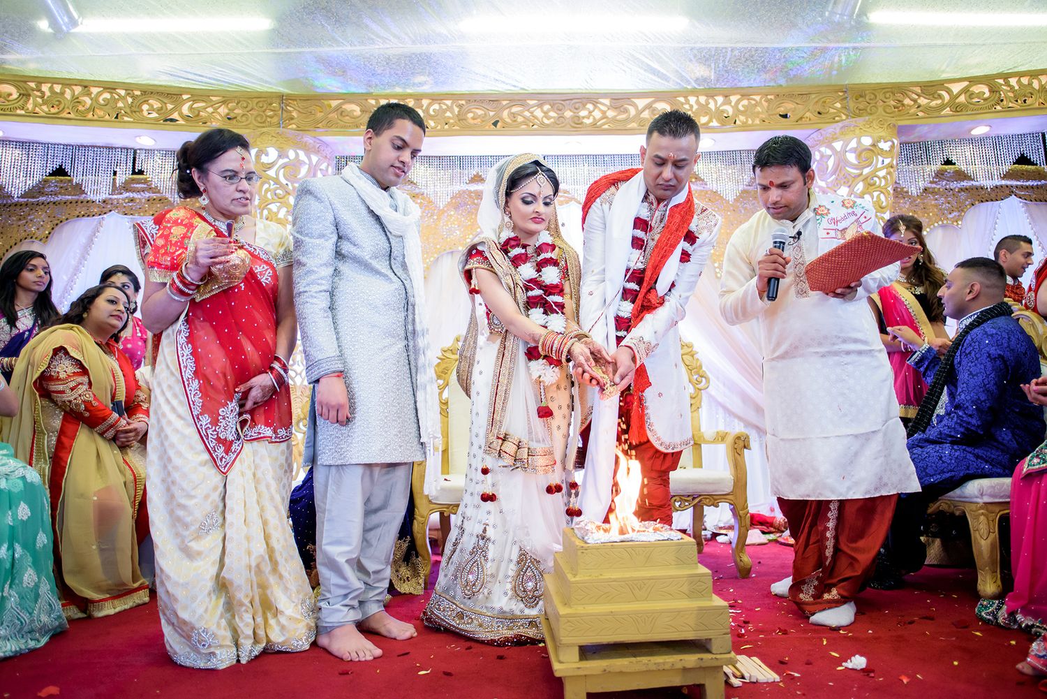 Panoramic view of traditional Indian wedding ceremony with guests in colorful attire.
