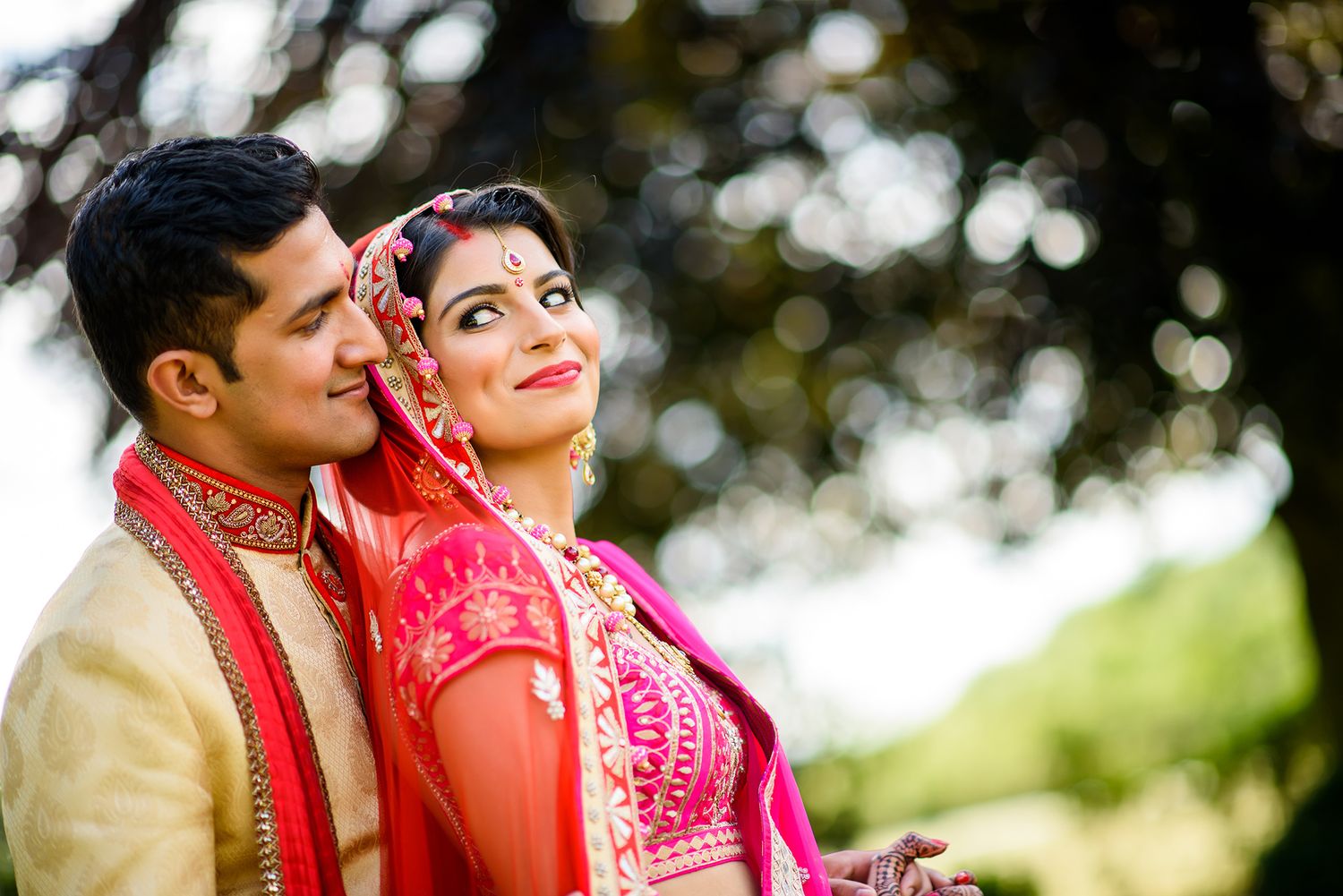 Intimate wedding couple portraits captured in a sun-dappled garden setting.