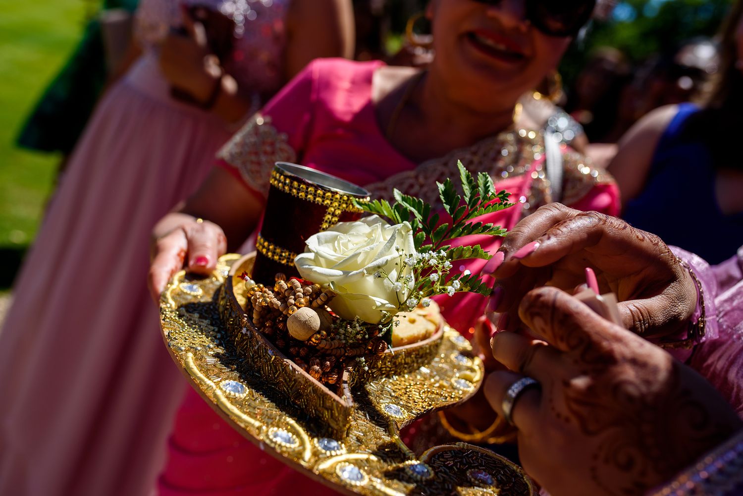 Ornate golden platters of food being served at a wedding reception.