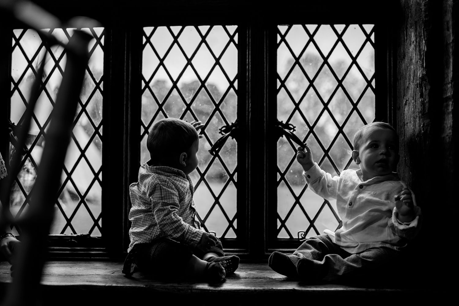 Historic leaded glass windows in black and white feature diamond patterned muntins.