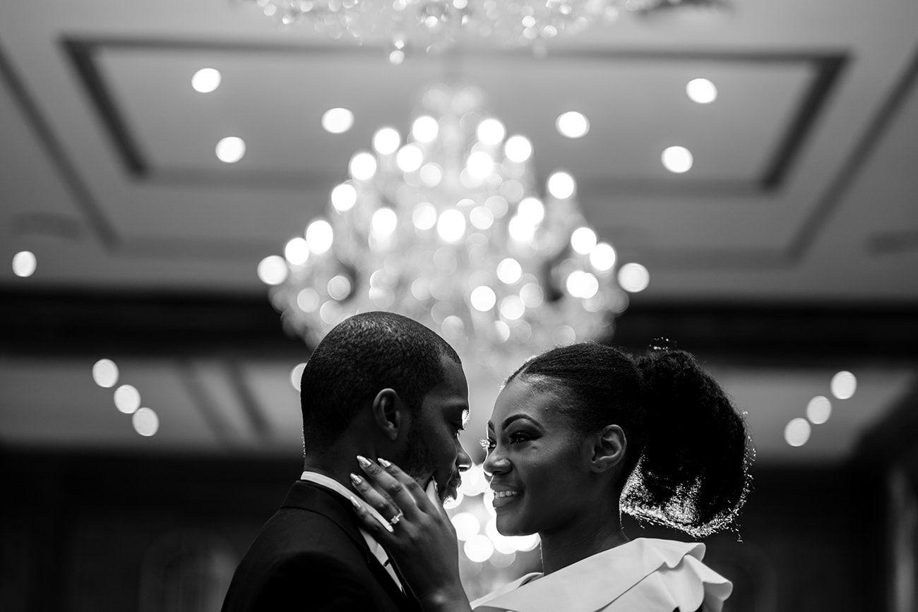 Reception hall with glittering chandeliers and elegant decor during an evening celebration.