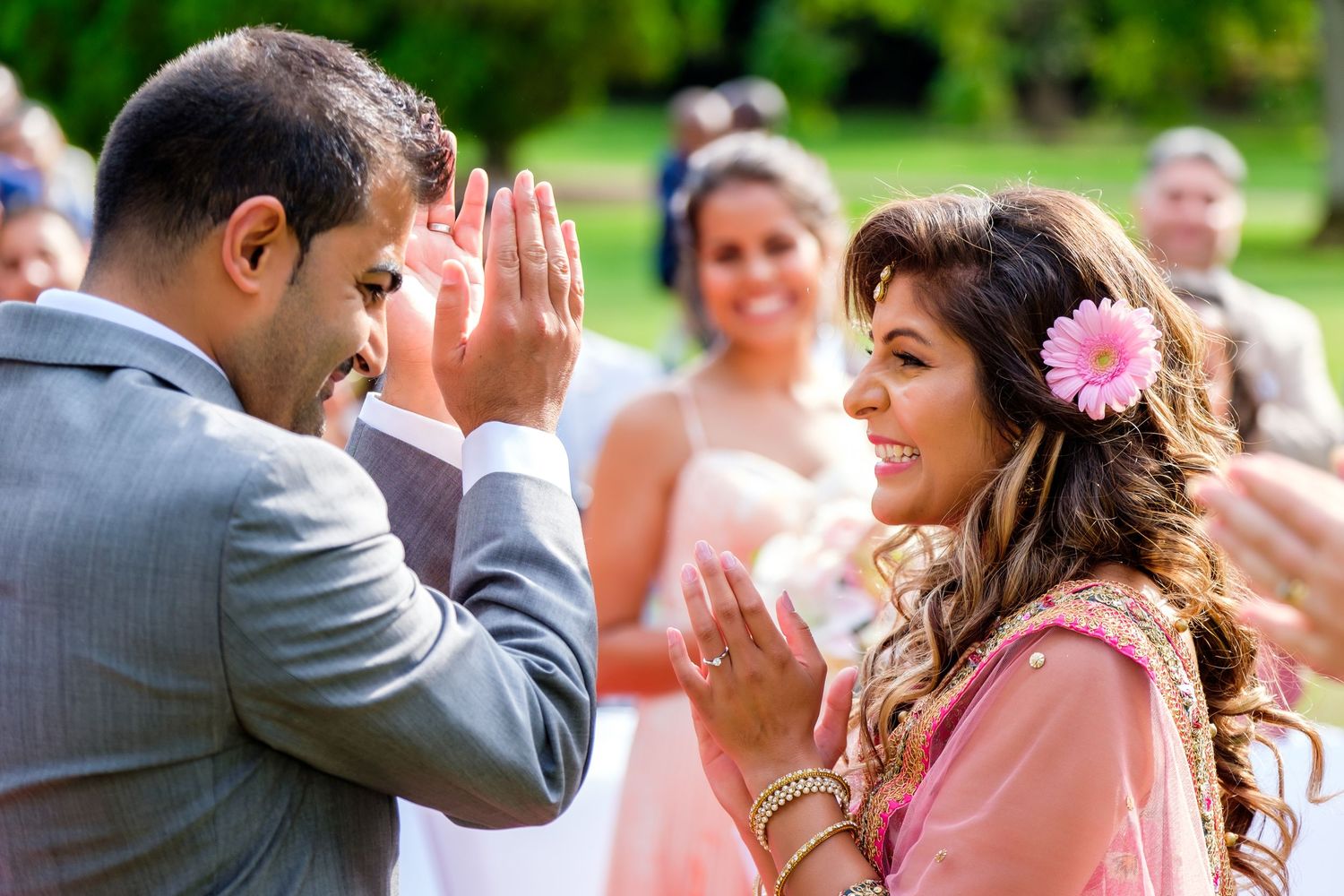 Wedding guests throw confetti and celebrate outdoors in joyful post-ceremony moment.