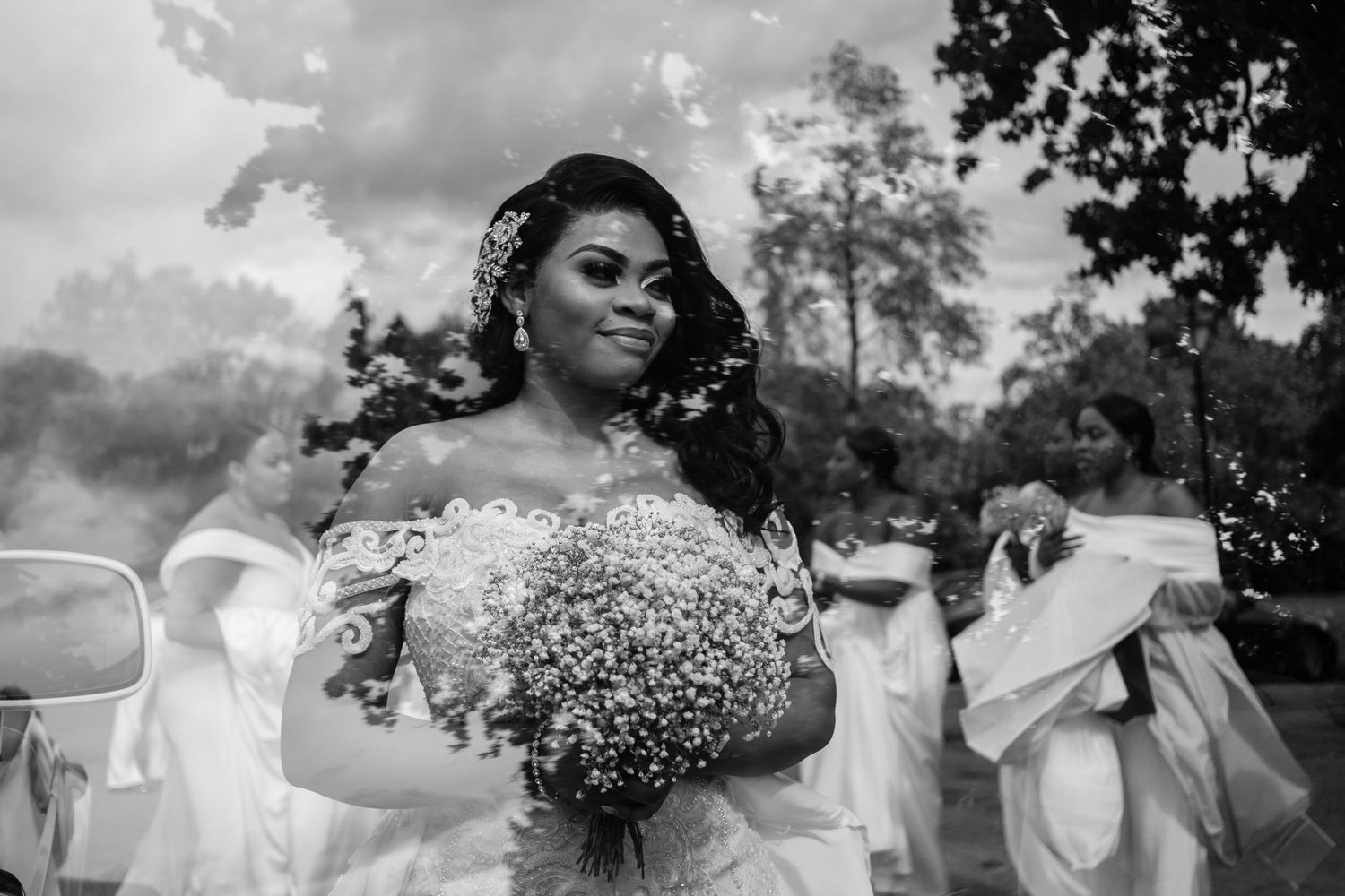 Wedding party celebrating outdoors under cloudy skies with baby's breath bouquets.