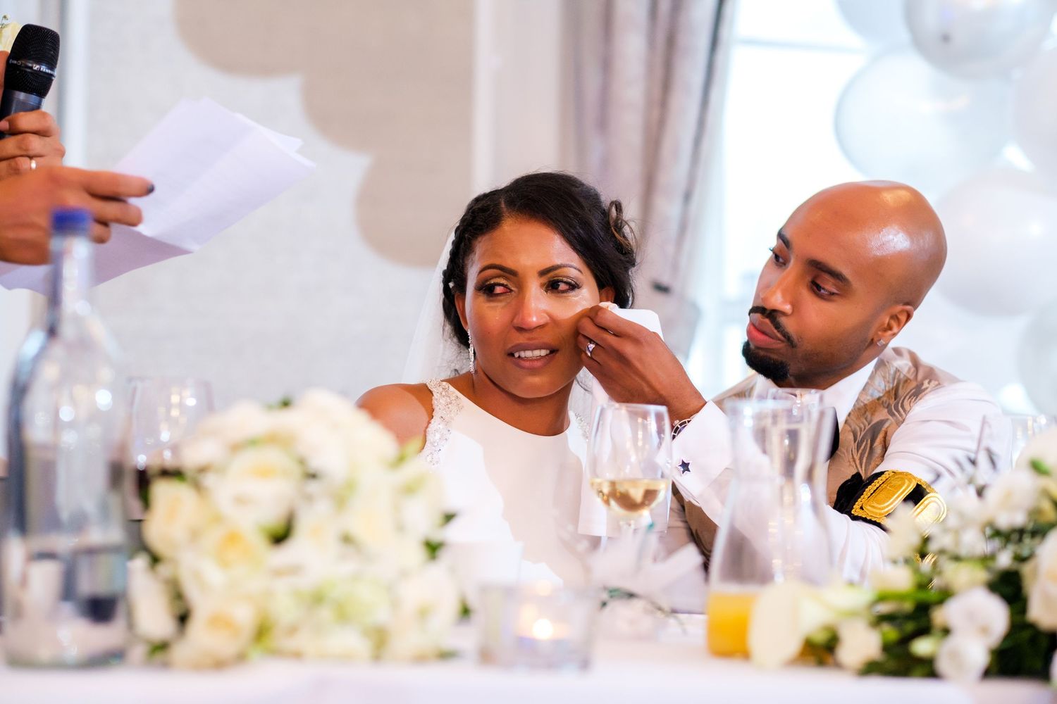 Wedding reception guests seated at decorated tables during dinner service.